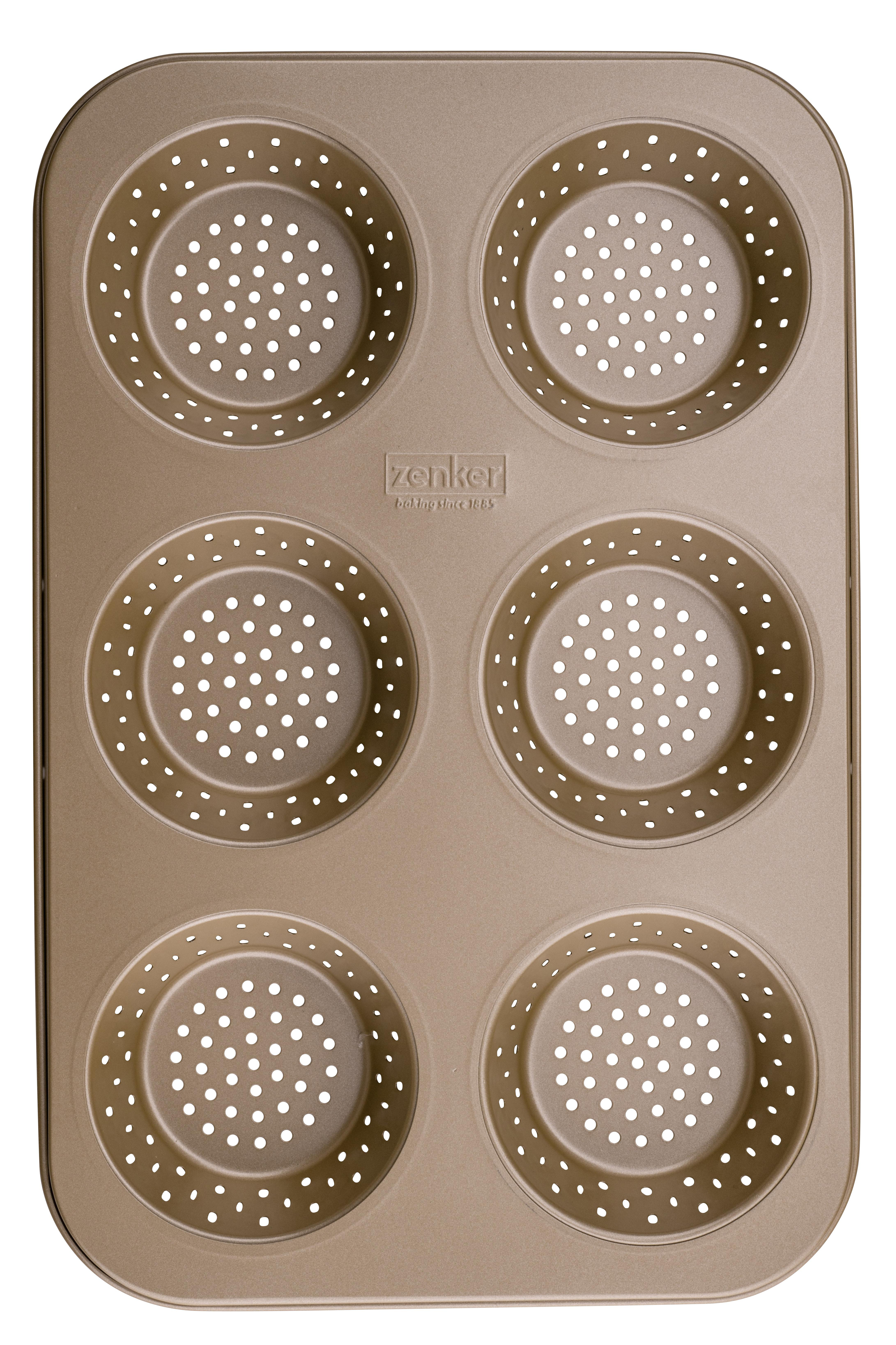 Eine goldfarbene Backform mit sechs kreisförmigen Formen, jede mit kleinen Perforationen.