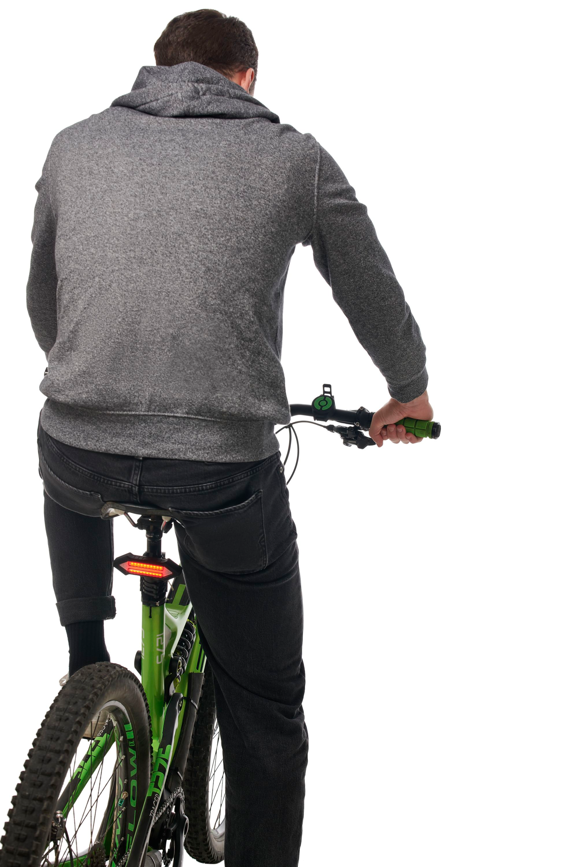 Una persona in sella a una bicicletta verde, vista da dietro. La persona indossa una felpa grigia.