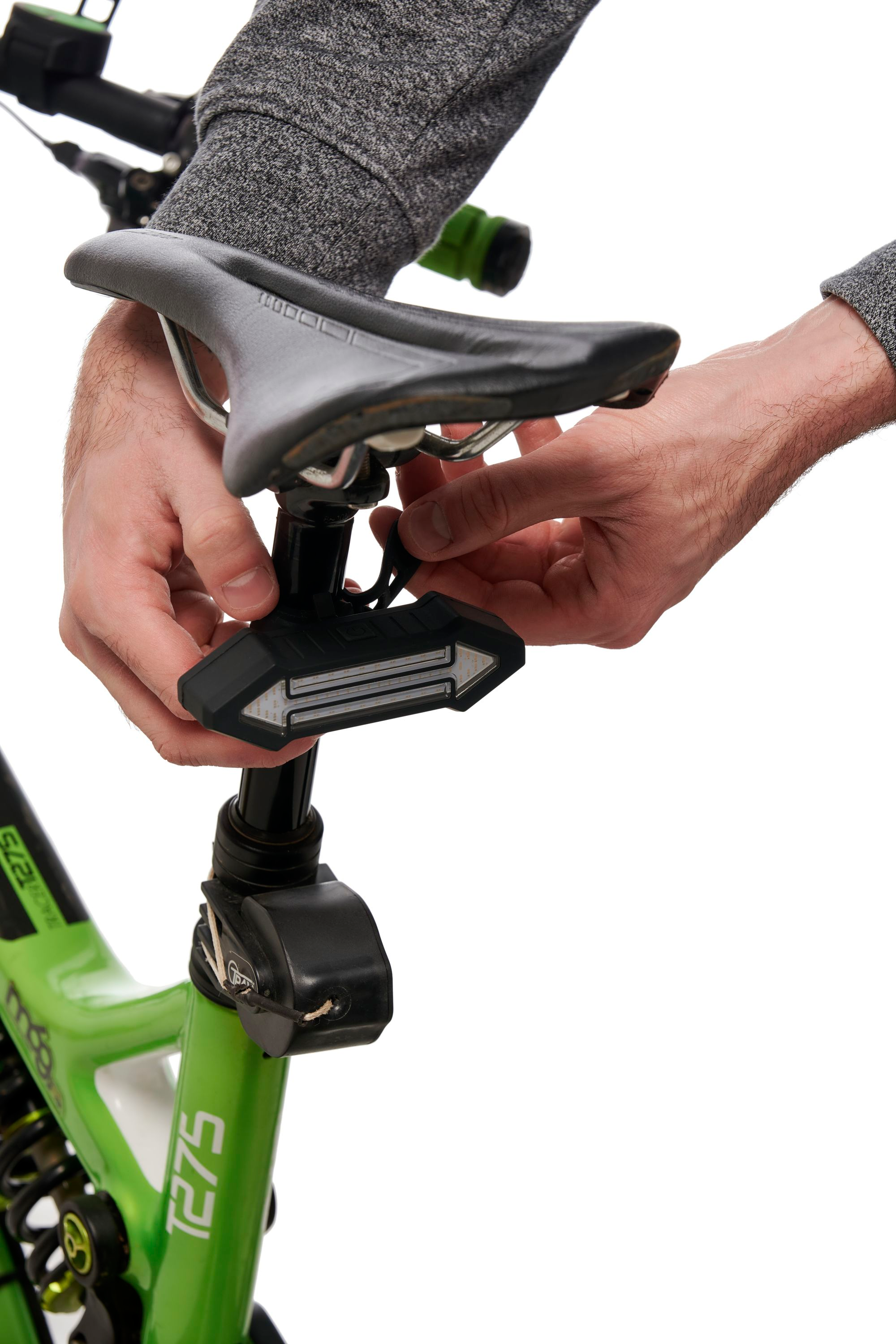 Mani di una persona che regola una luce per bici attaccata al reggisella.