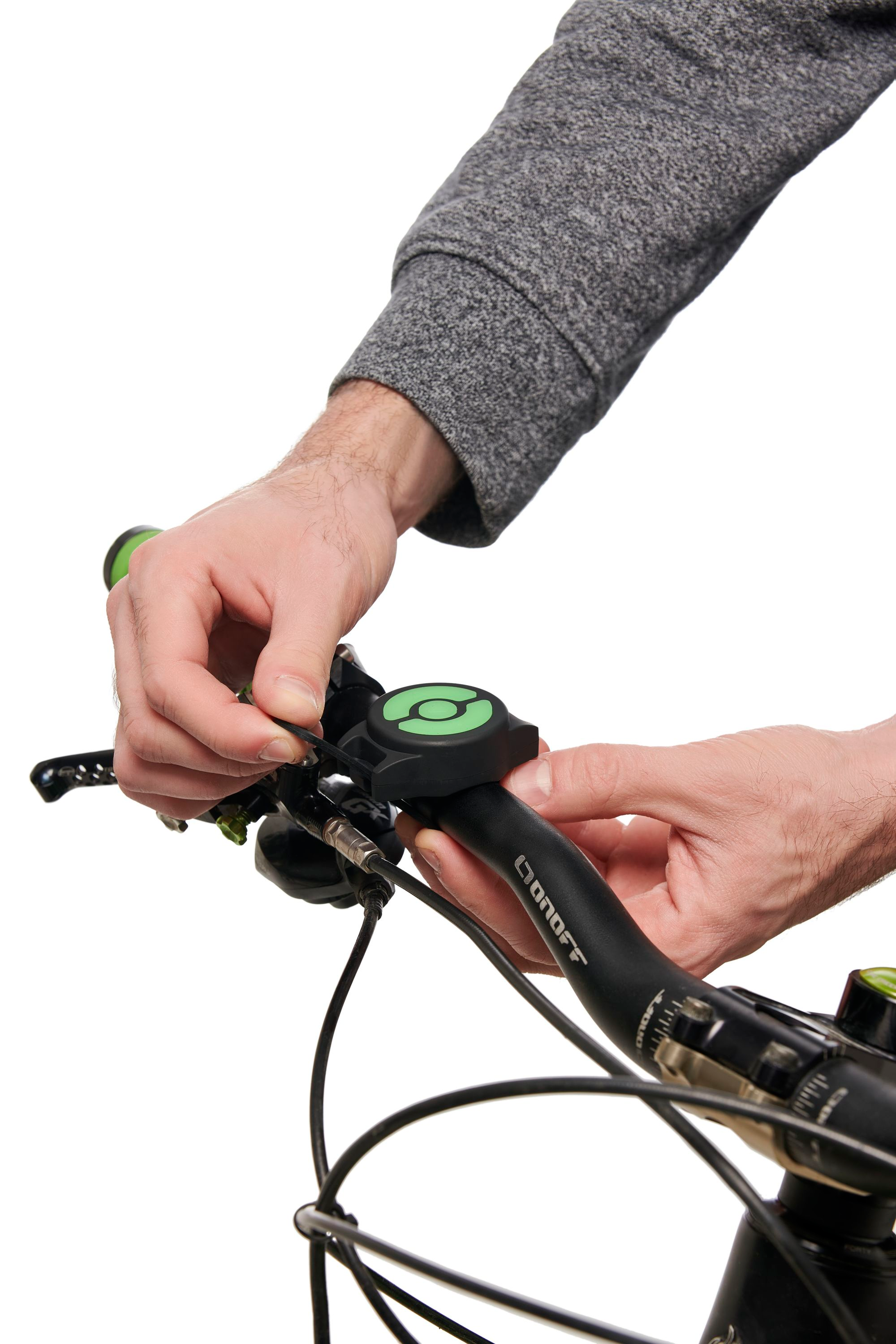 Mani che regolano un campanello da bici su un manubrio nero.
