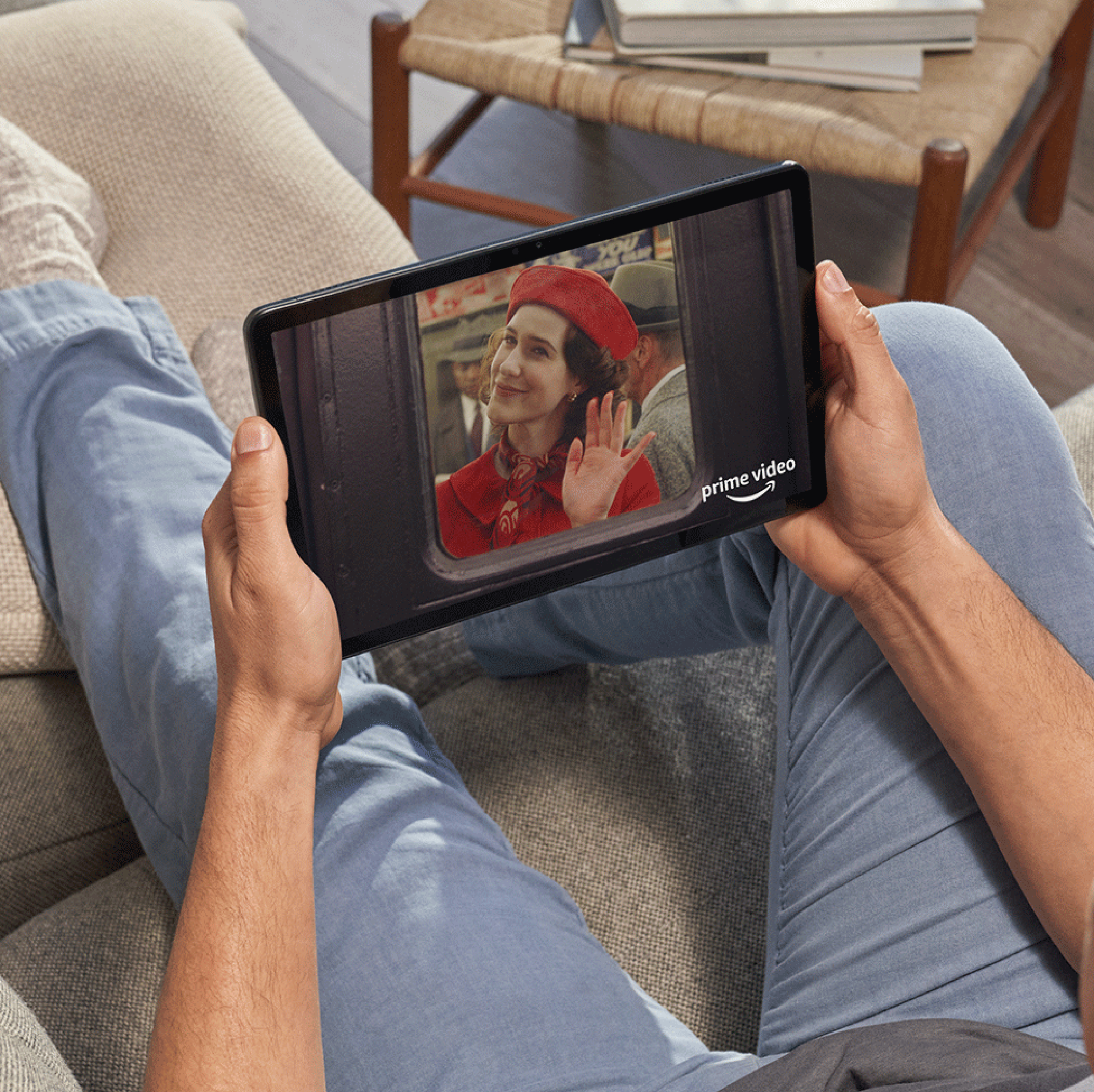 Person hält ein Tablet mit einer Filmszene und dem Prime Video-Logo.