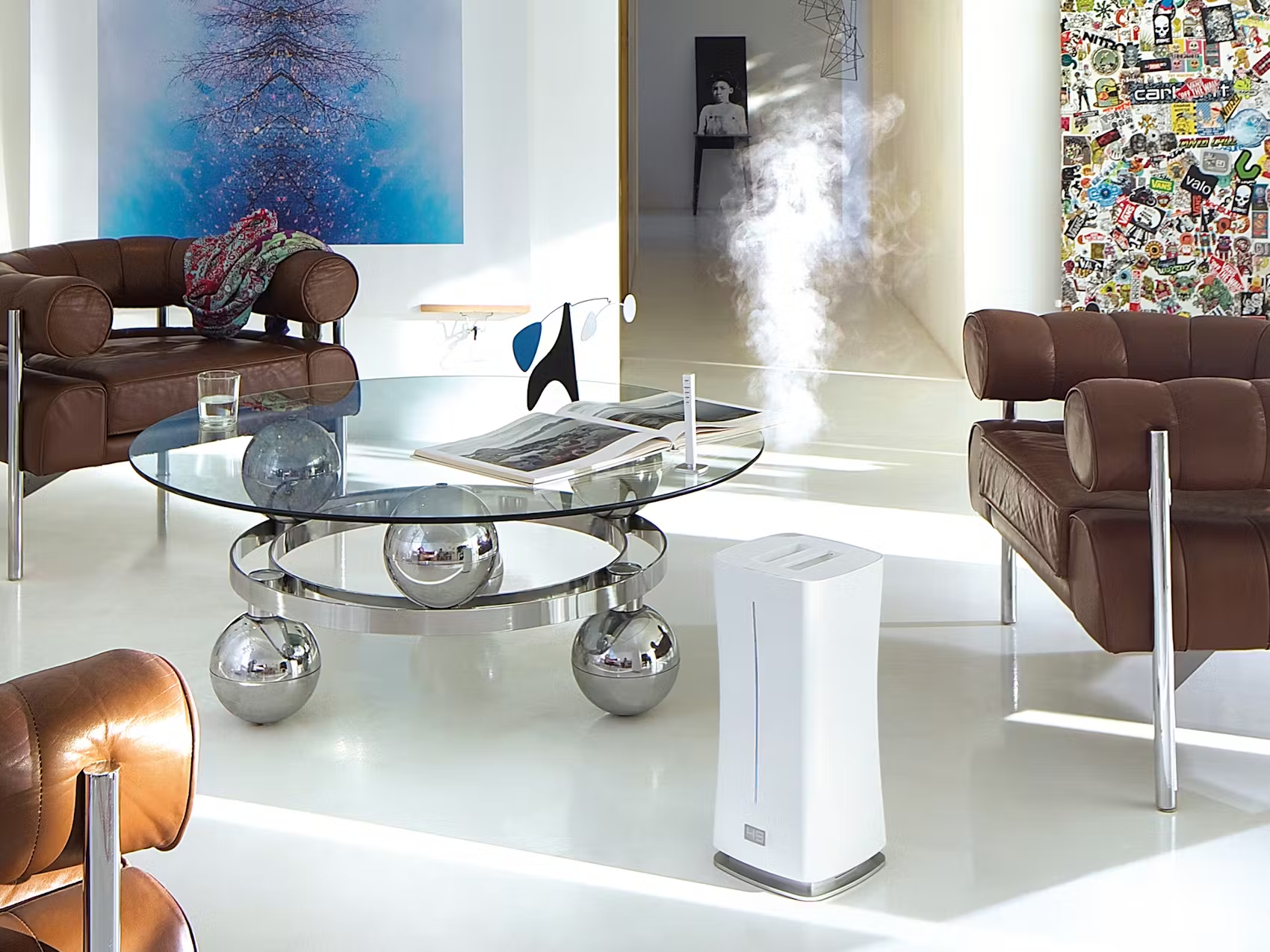 Ein modernes Wohnzimmer mit einem Luftbefeuchter, Sofas und einem gläsernen Couchtisch.