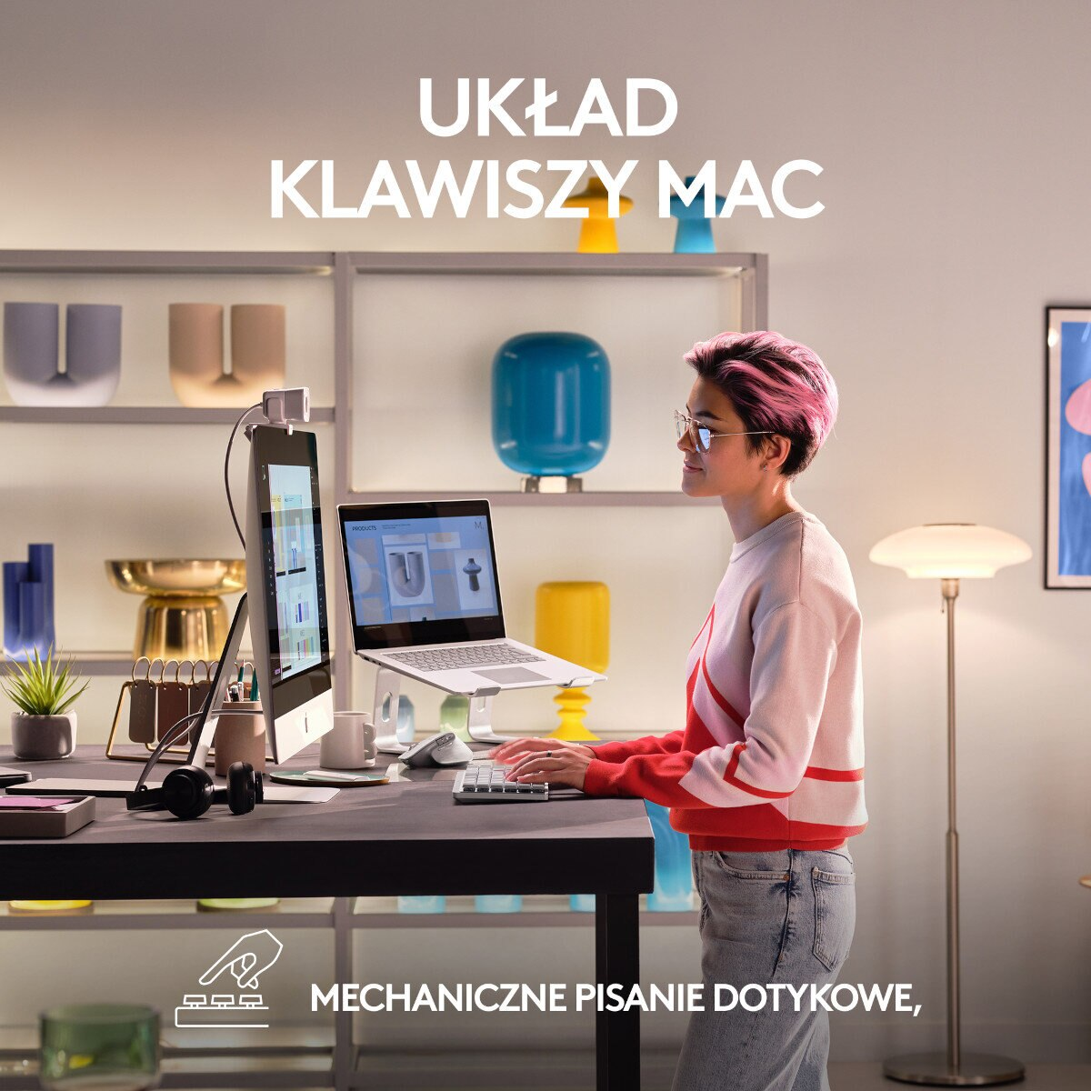 Kobieta pracuje na konfiguracji Mac z laptopem, monitorem i akcesoriami przy biurku w domowym biurze.