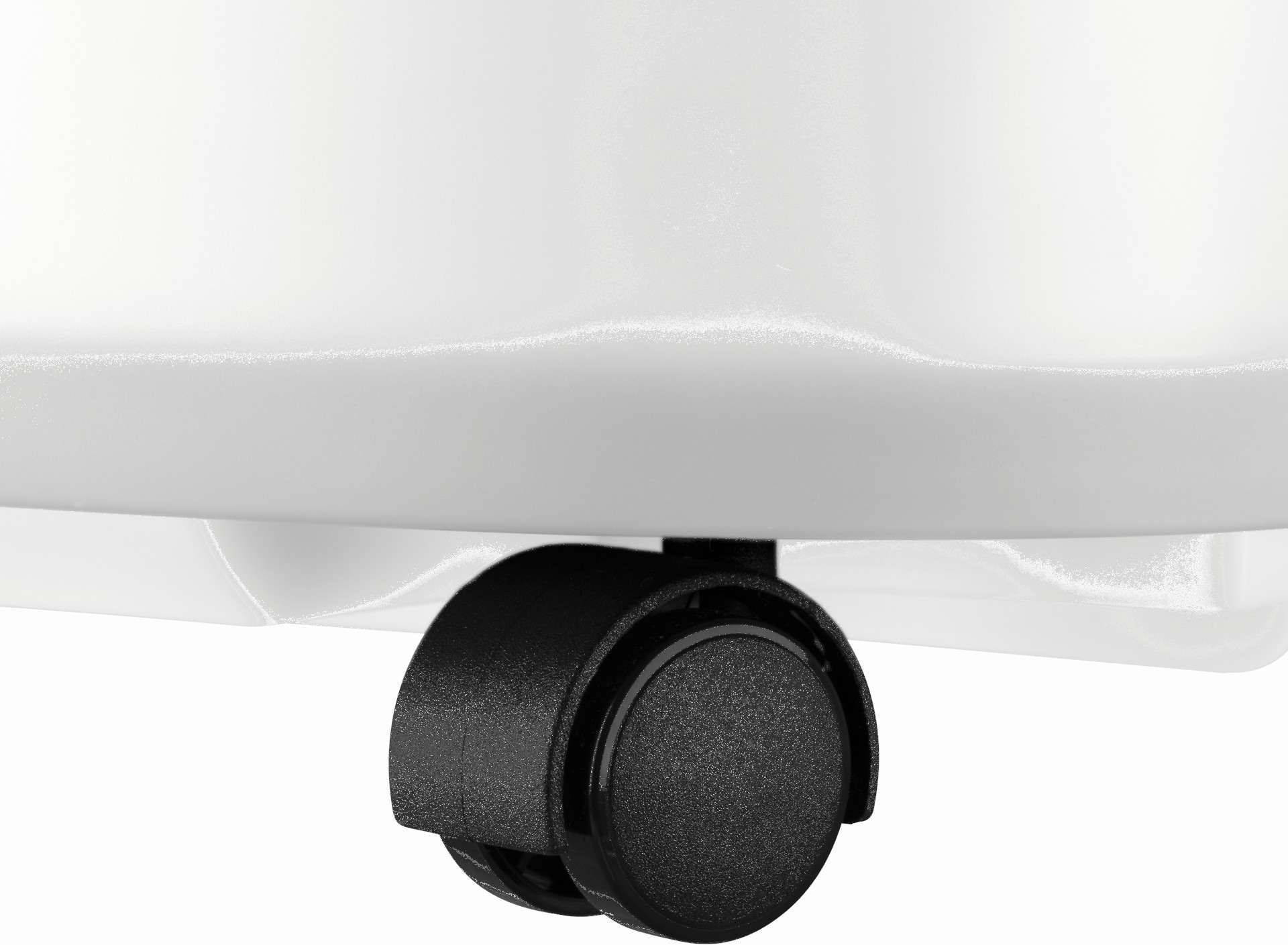 Gros plan d'une roulette noire fixée à un objet blanc. La roue est ronde avec une surface texturée.