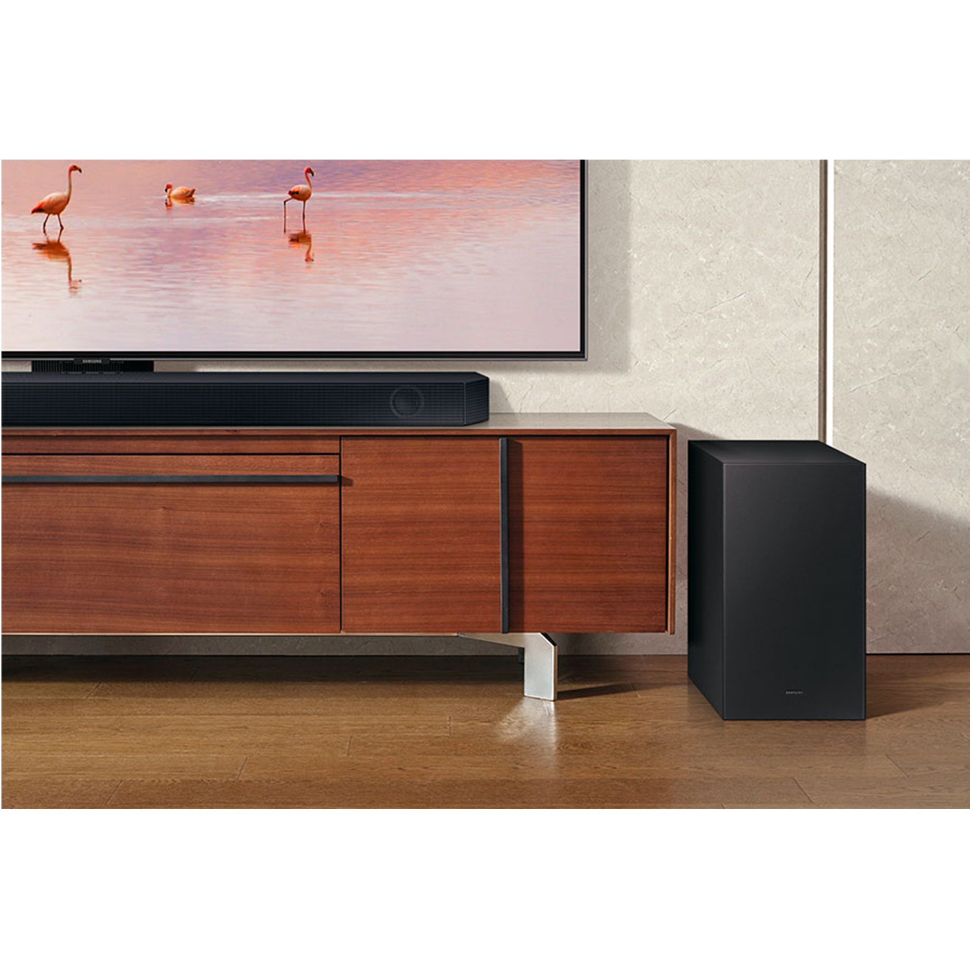 Configuración de sala: TV, barra de sonido y subwoofer en mueble de madera. Fondo con pintura de flamencos.