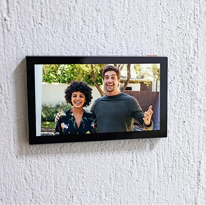 Un marco de fotos digital en una pared texturizada, mostrando una pareja.