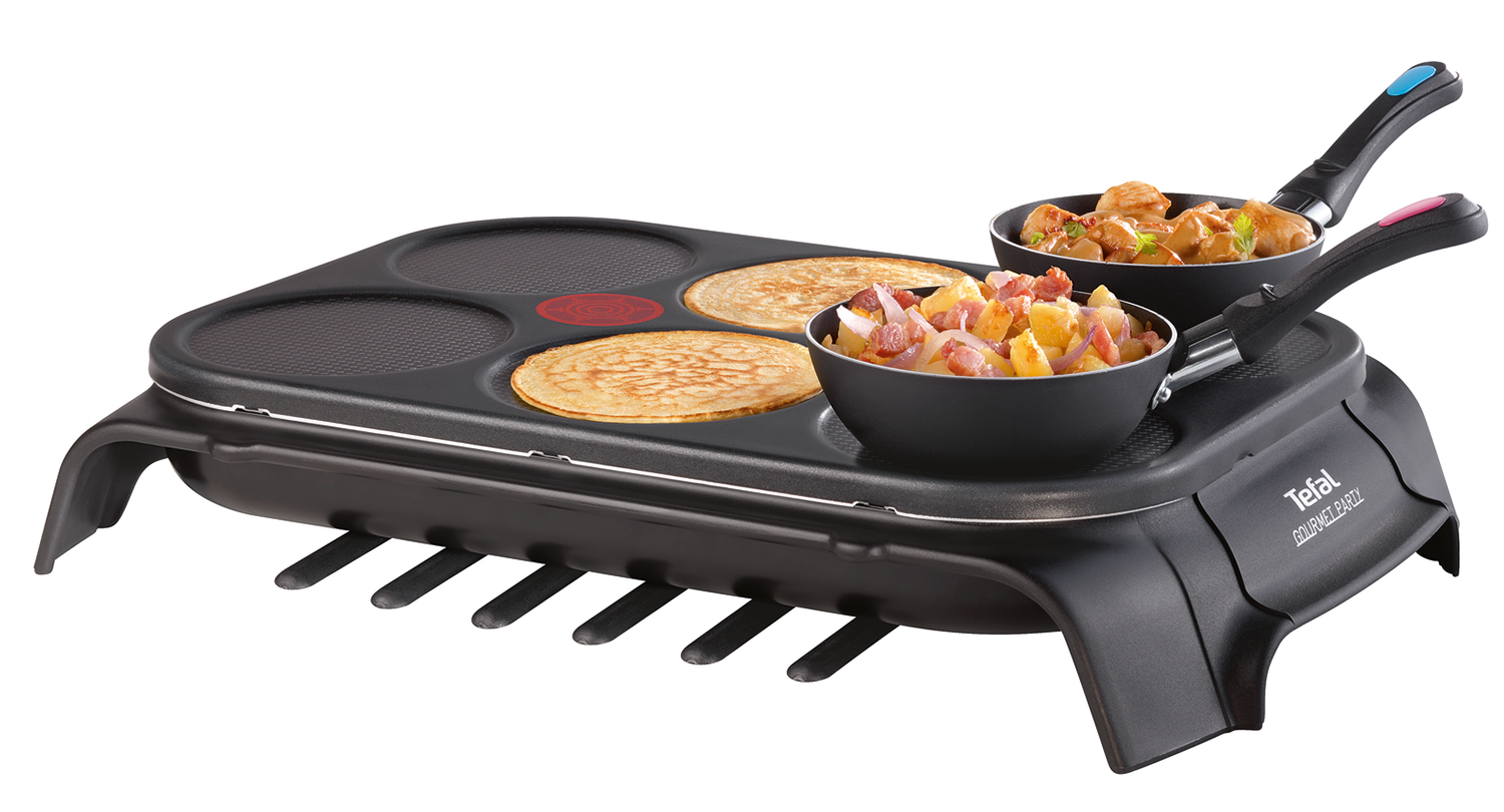 A pancake maker with pancakes and food inside two small pans on the device.