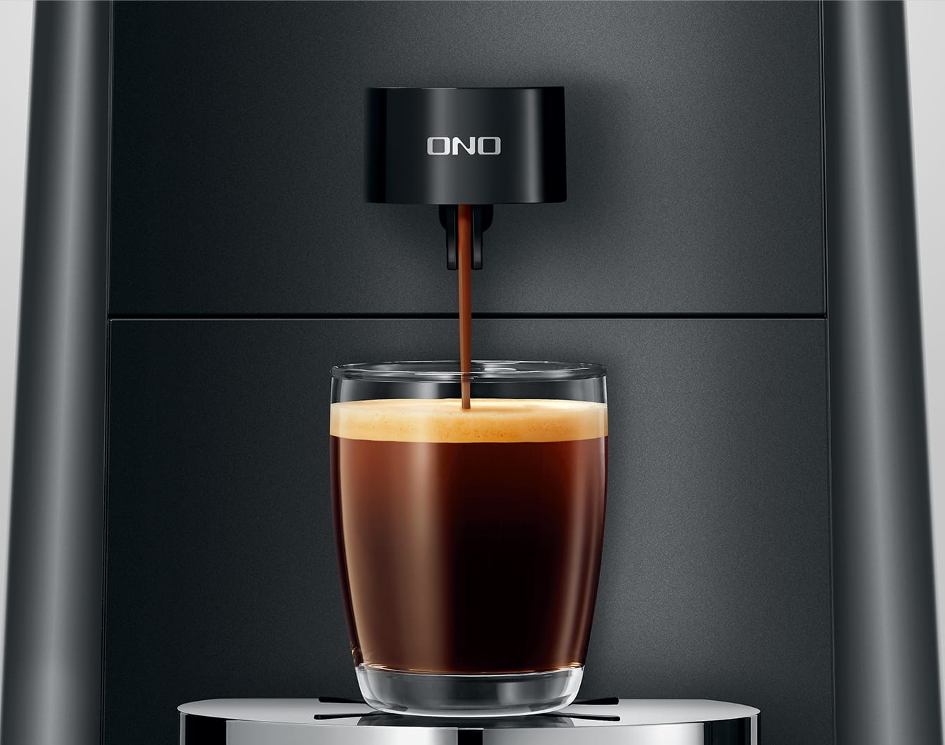 Kaffeemaschine, die Kaffee in ein Glas abgibt. Die Maschine ist schwarz mit silbernen Akzenten.