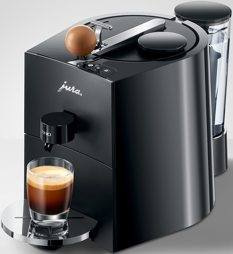 Eine schwarze Jura Kaffeemaschine mit einem Glas Espresso. Sie hat einen Wassertank und einen braunen Knopf.