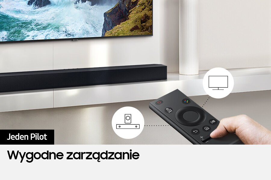 Osoba trzymająca pilota. Telewizor i soundbar w tle.
