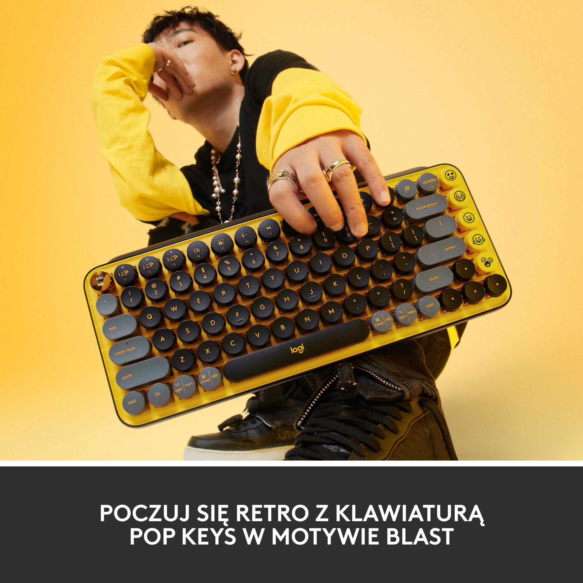 Osoba trzymająca żółto-czarną klawiaturę z okrągłymi klawiszami.