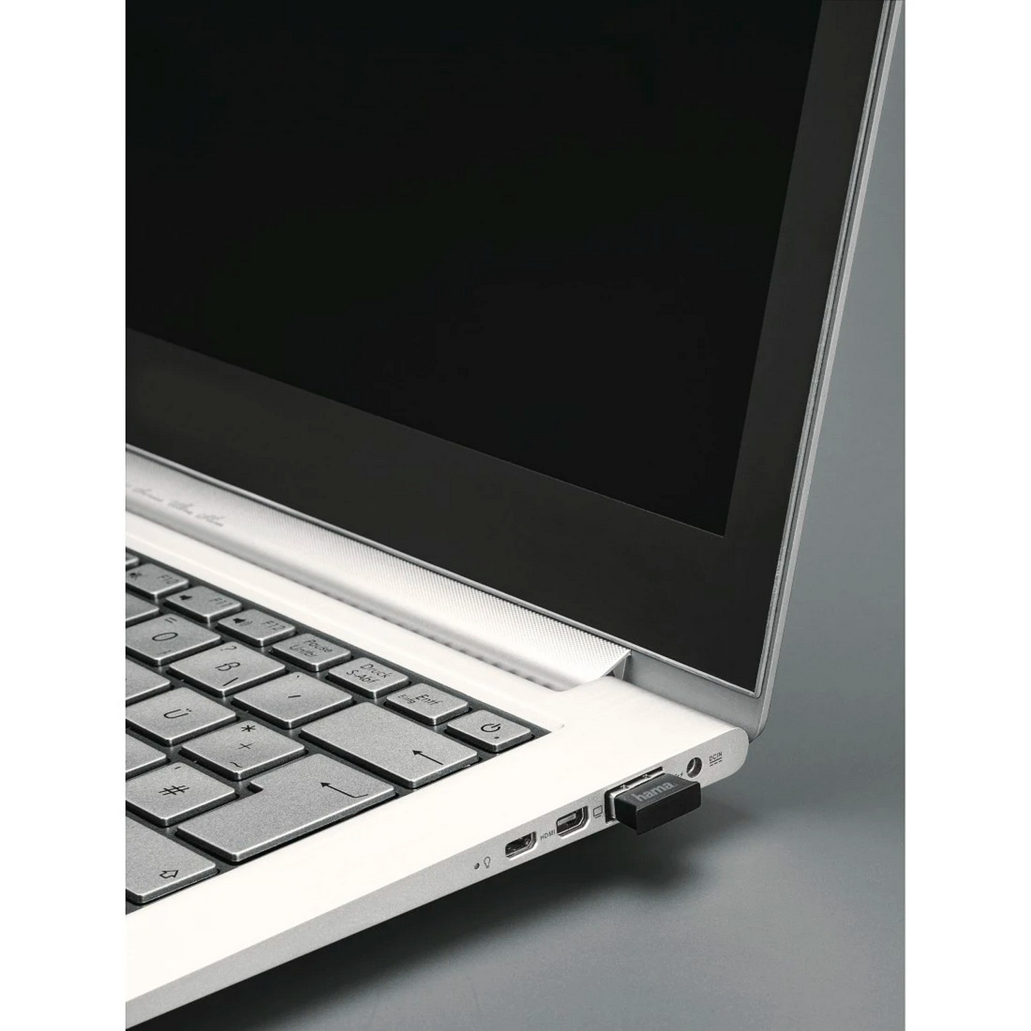 Ordinateur portable avec une clé USB noire insérée. L'écran est noir. Clavier et ports visibles.