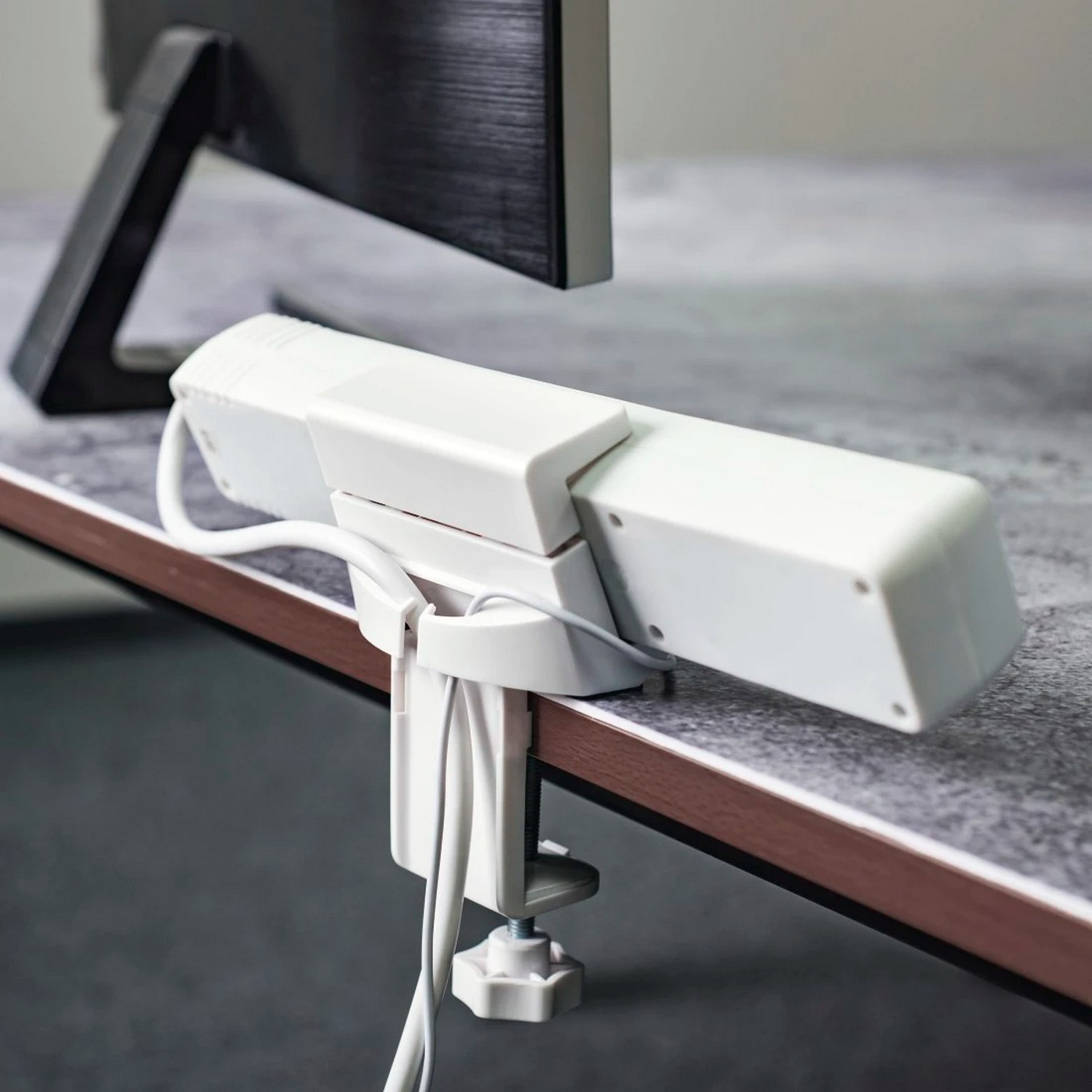 Une lumière blanche pour moniteur d'ordinateur, fixée à un bureau.