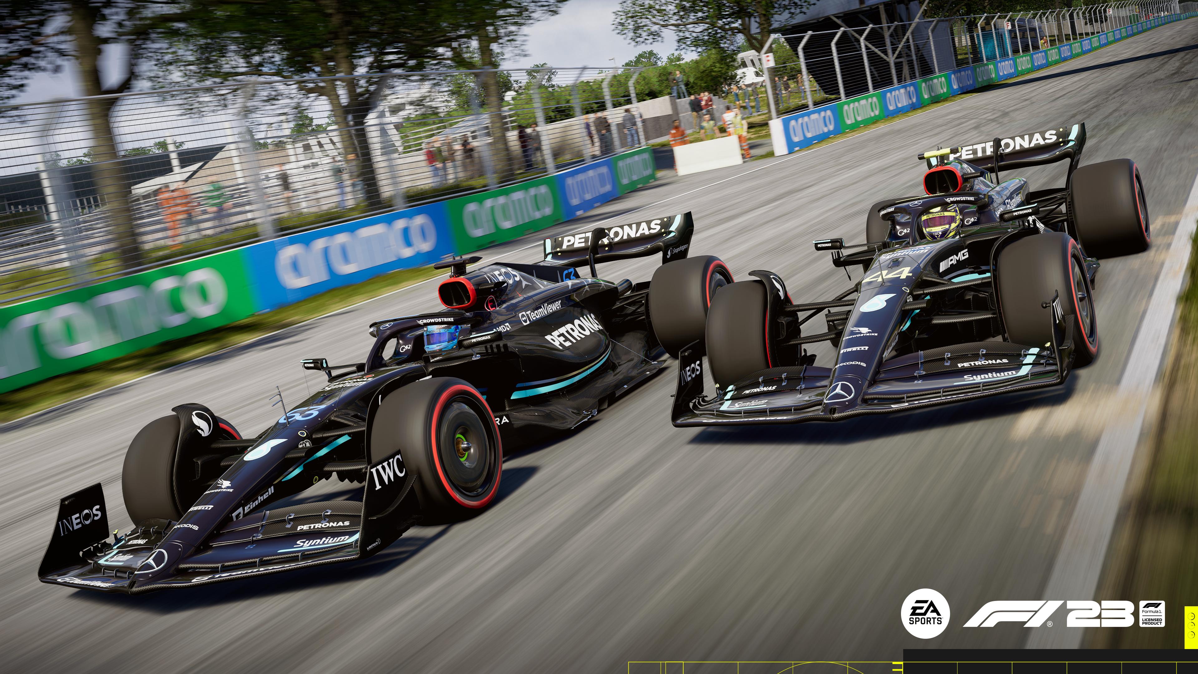 Zwei schwarze Formel-1-Autos auf einer Rennstrecke, mit Sponsorenlogos und einer grün-blauen Barriere.