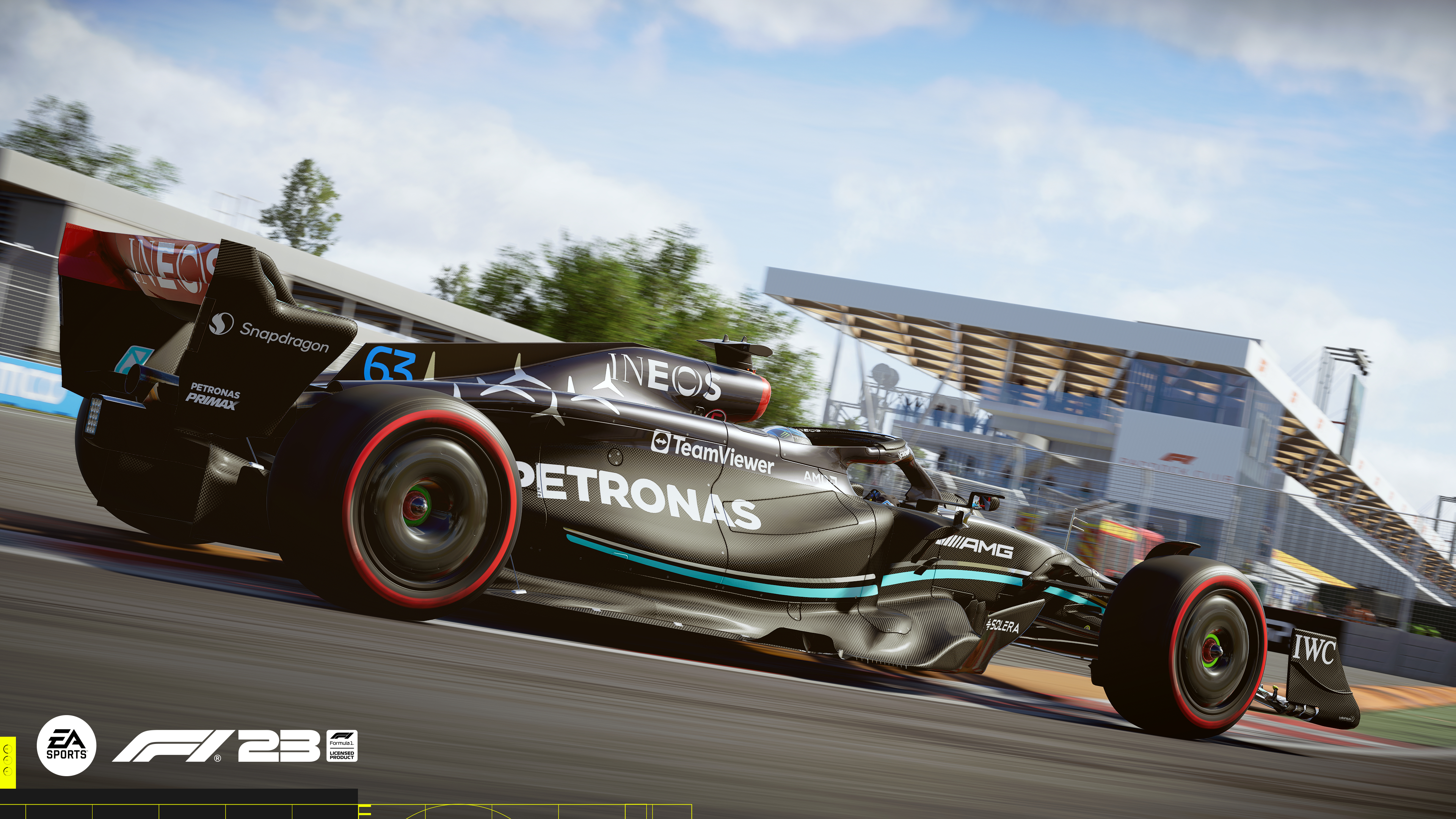 Ein Formel-1-Auto fährt auf einer Rennstrecke. Das Auto ist schwarz mit blauen und weißen Akzenten und der Himmel ist blau.