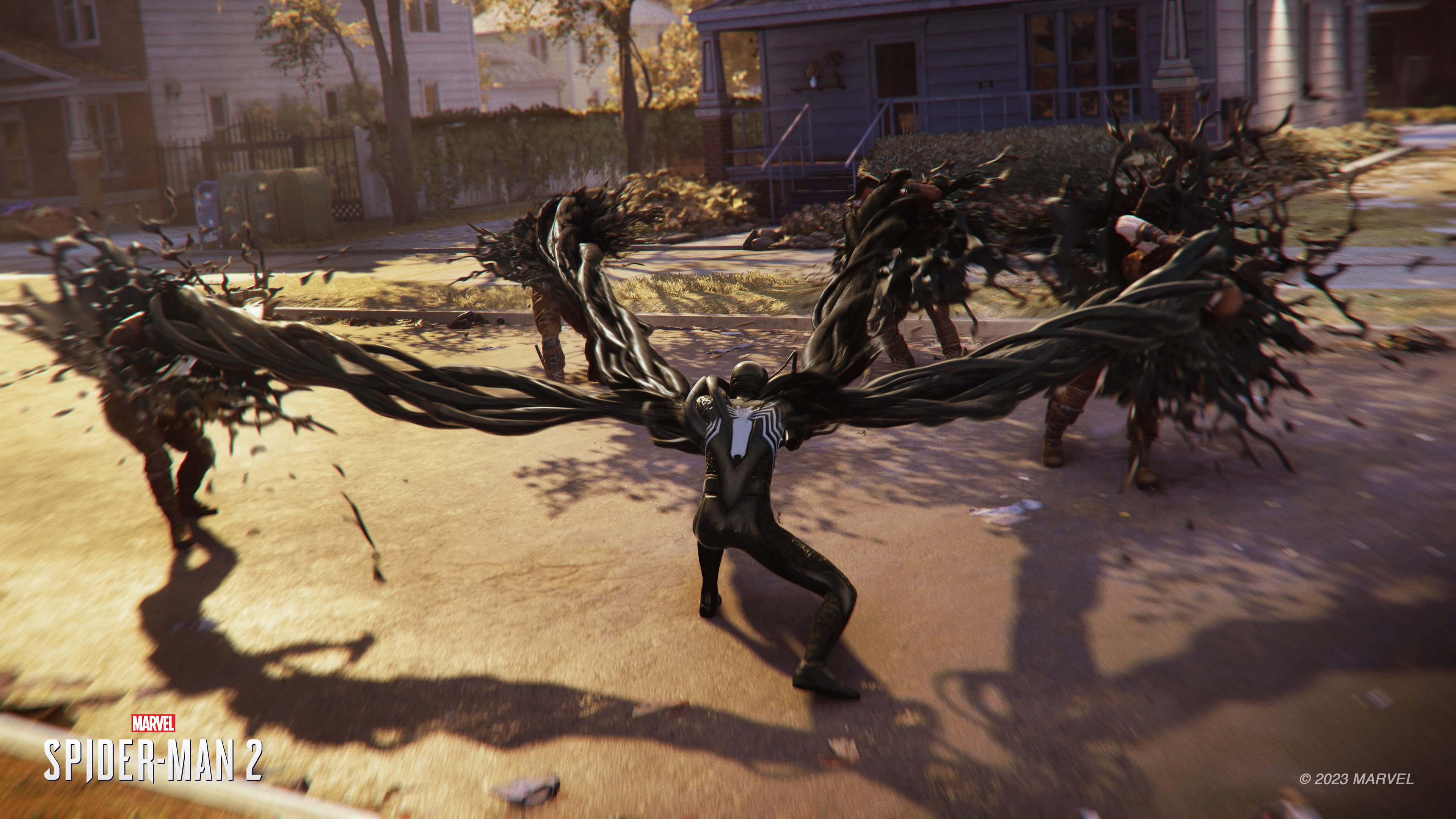 Venom Spider-Man contro i nemici. Hanno tentacoli neri, strada con foglie autunnali sullo sfondo.