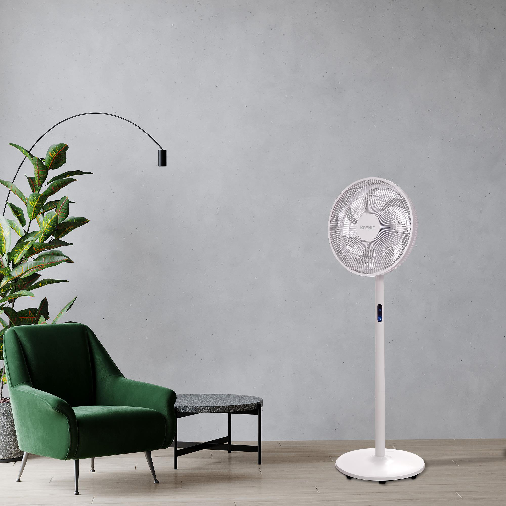 Weißer Ventilator in einem Raum mit grünem Stuhl.