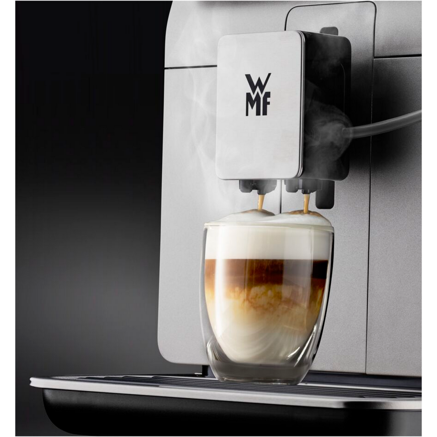 Coffee machine dispensing coffee into a glass. Steam is visible.