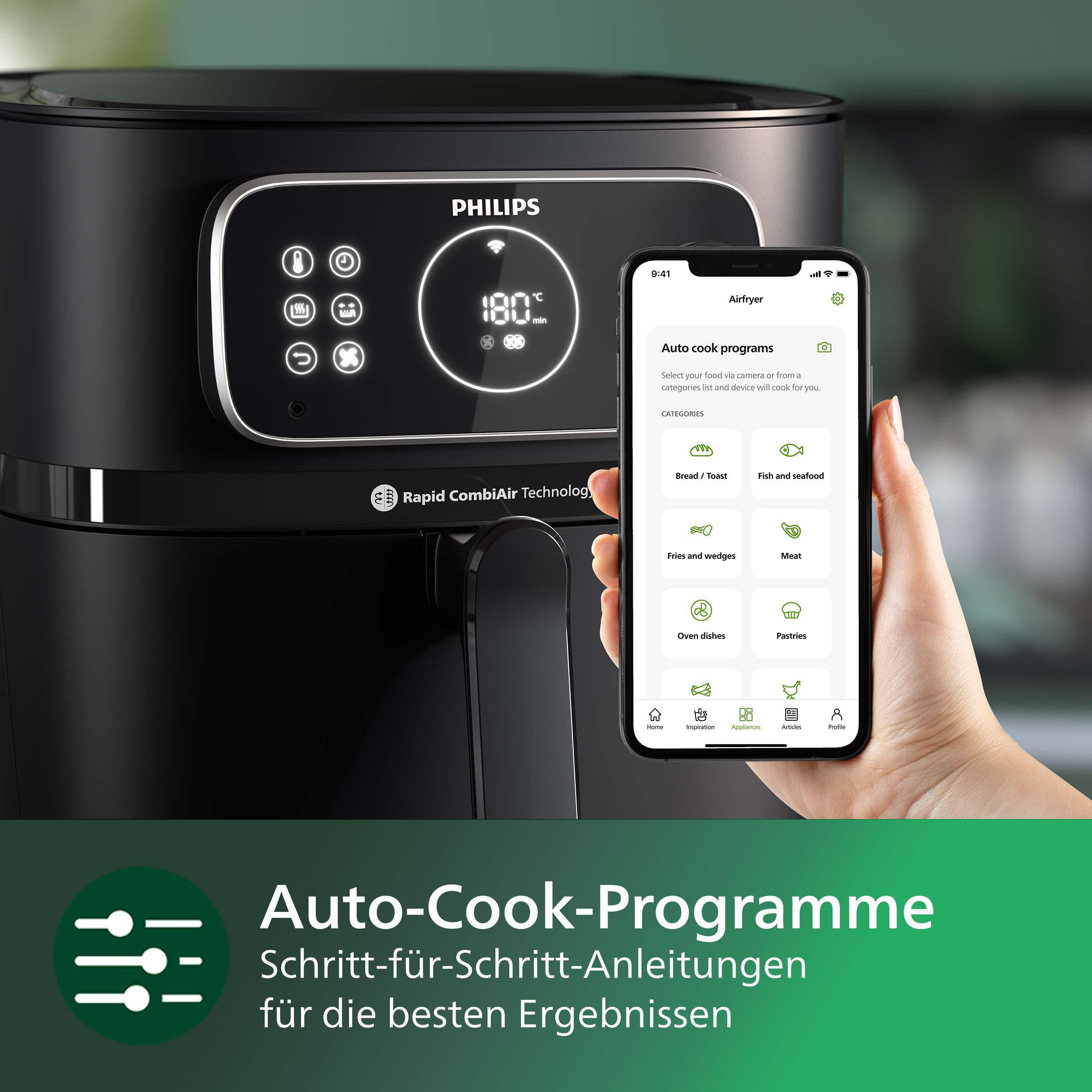 Schwarze Heißluftfritteuse mit Telefon, das Rezepte anzeigt. Eine Hand interagiert mit dem Telefon.