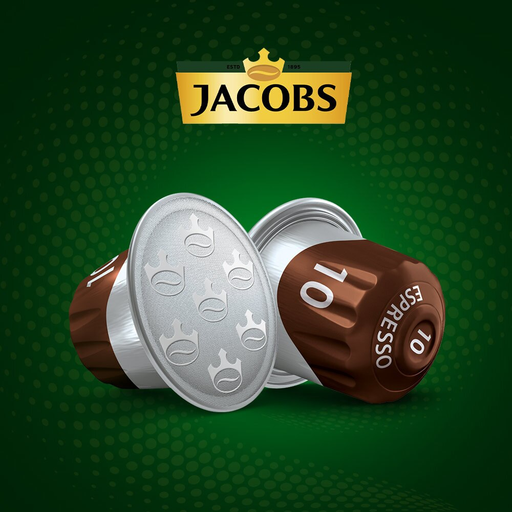 Kapsułki do kawy. Brązowe i srebrne kapsułki z logo Jacobs na zielonym tle.