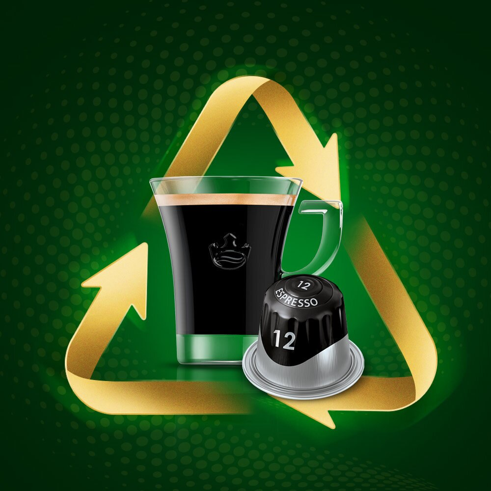 Filiżanka kawy, kapsułka i symbol recyklingu na zielonym tle.