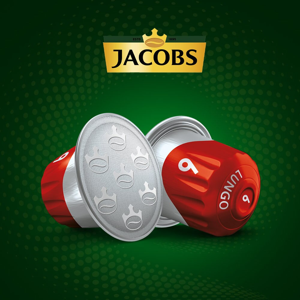Kapsułki do kawy Jacobs. Jedna otwarta, pokazująca kawę. Czerwone i srebrne kapsułki na zielonym tle.