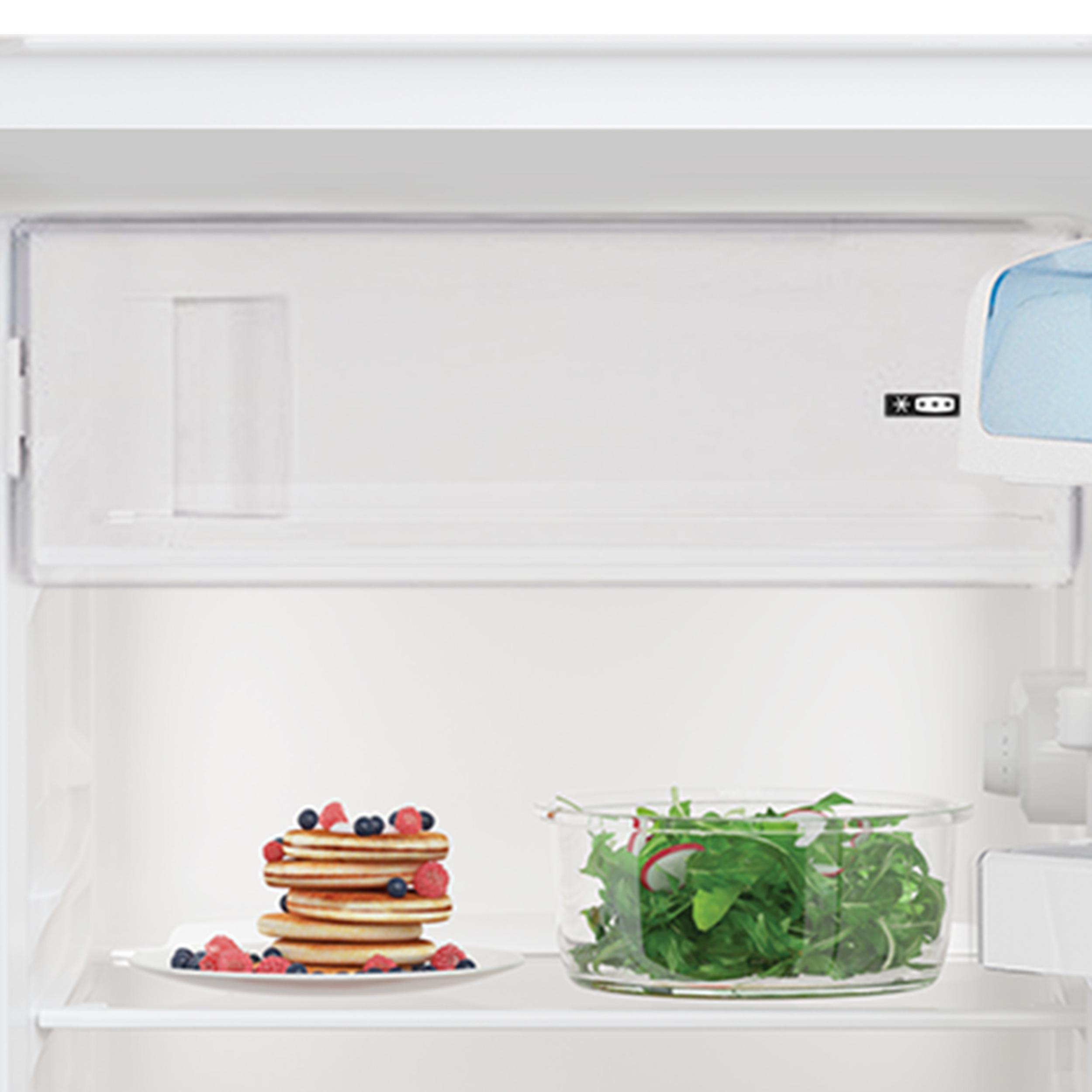 In einem Kühlschrank: Pfannkuchen und Salat auf einem Teller und in einer Schüssel.