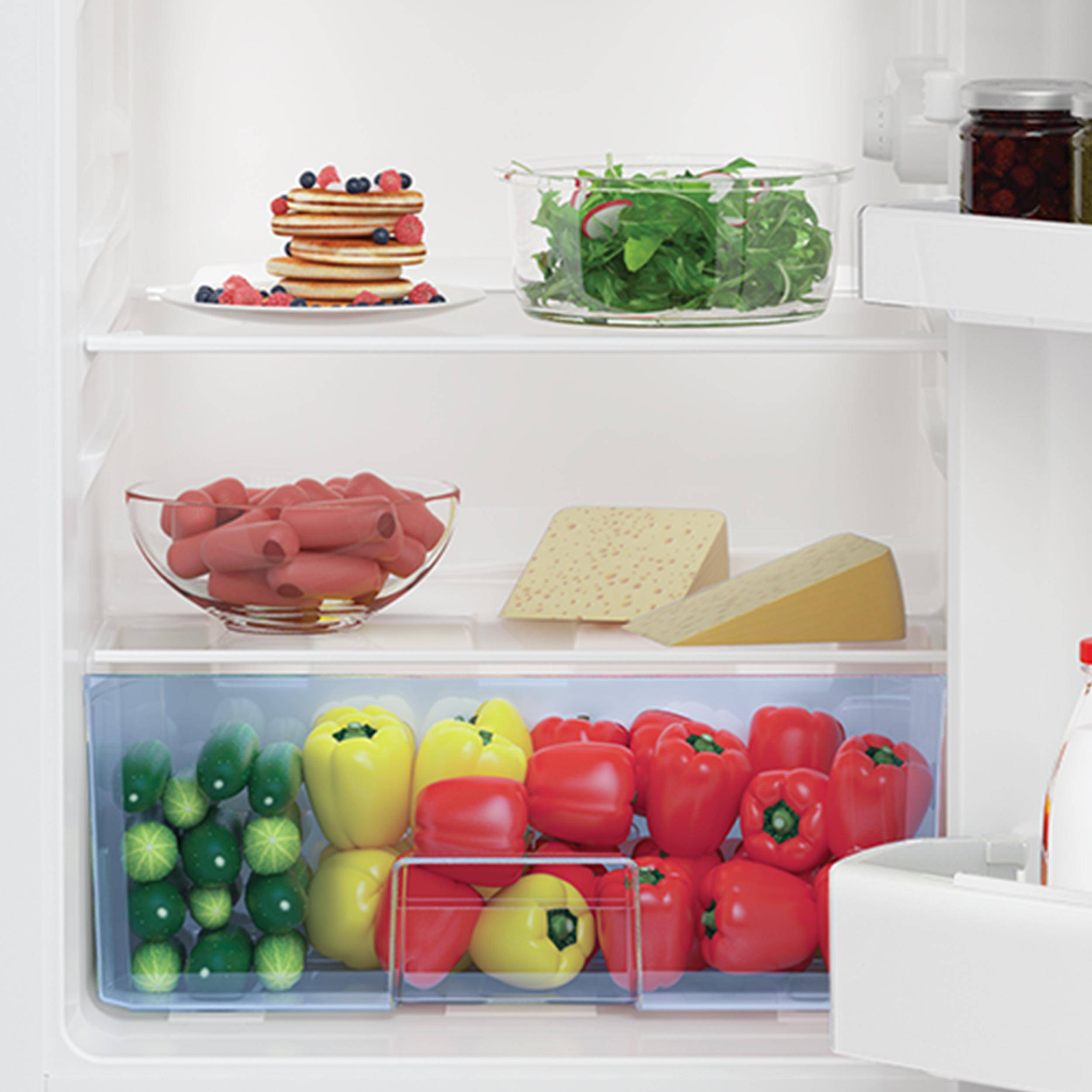 Ein Kühlschrank voller Lebensmittel: Pfannkuchen, Salat, Käse, Würstchen, Paprika und Tomaten.
