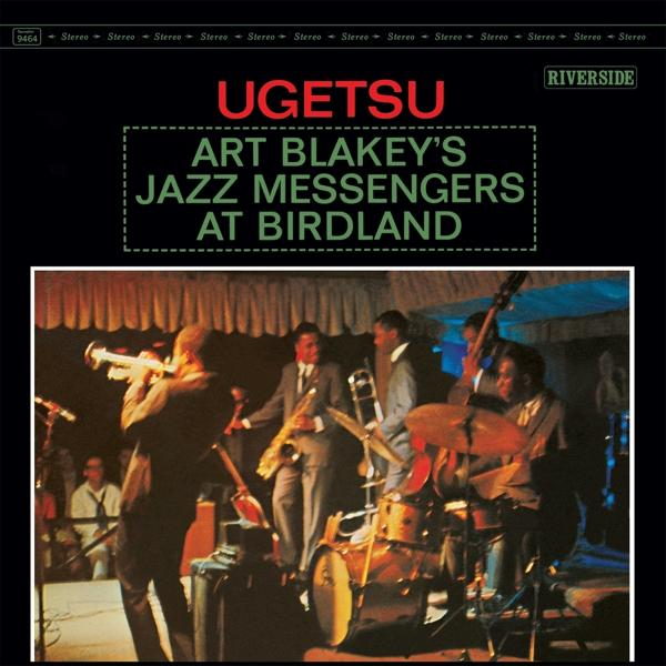 Art Blakey's Jazz Messengers At Birdland című album borítója. Zenekar a színpadon, hangszerek, fekete háttér.