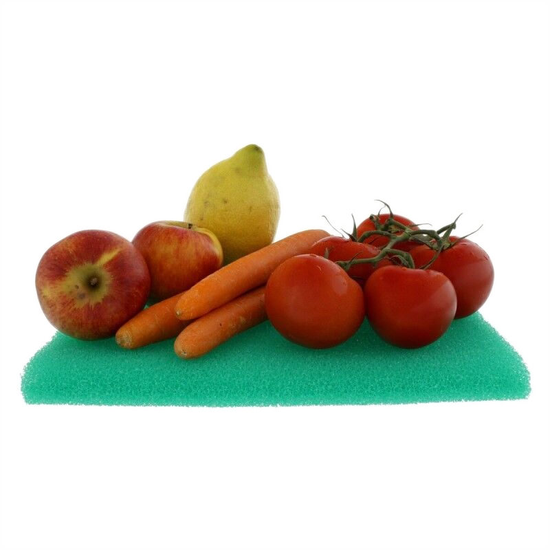 Imagen de frutas y verduras: manzanas, tomates, zanahorias y un limón sobre una superficie verde.