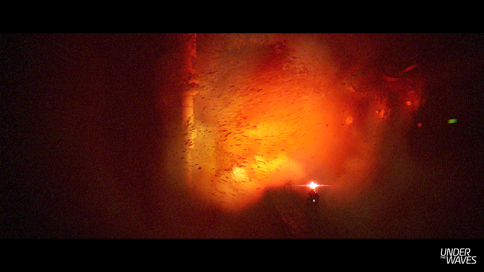 Image abstraite d'une lumière vive sur fond rouge foncé. Ressemble à du feu.