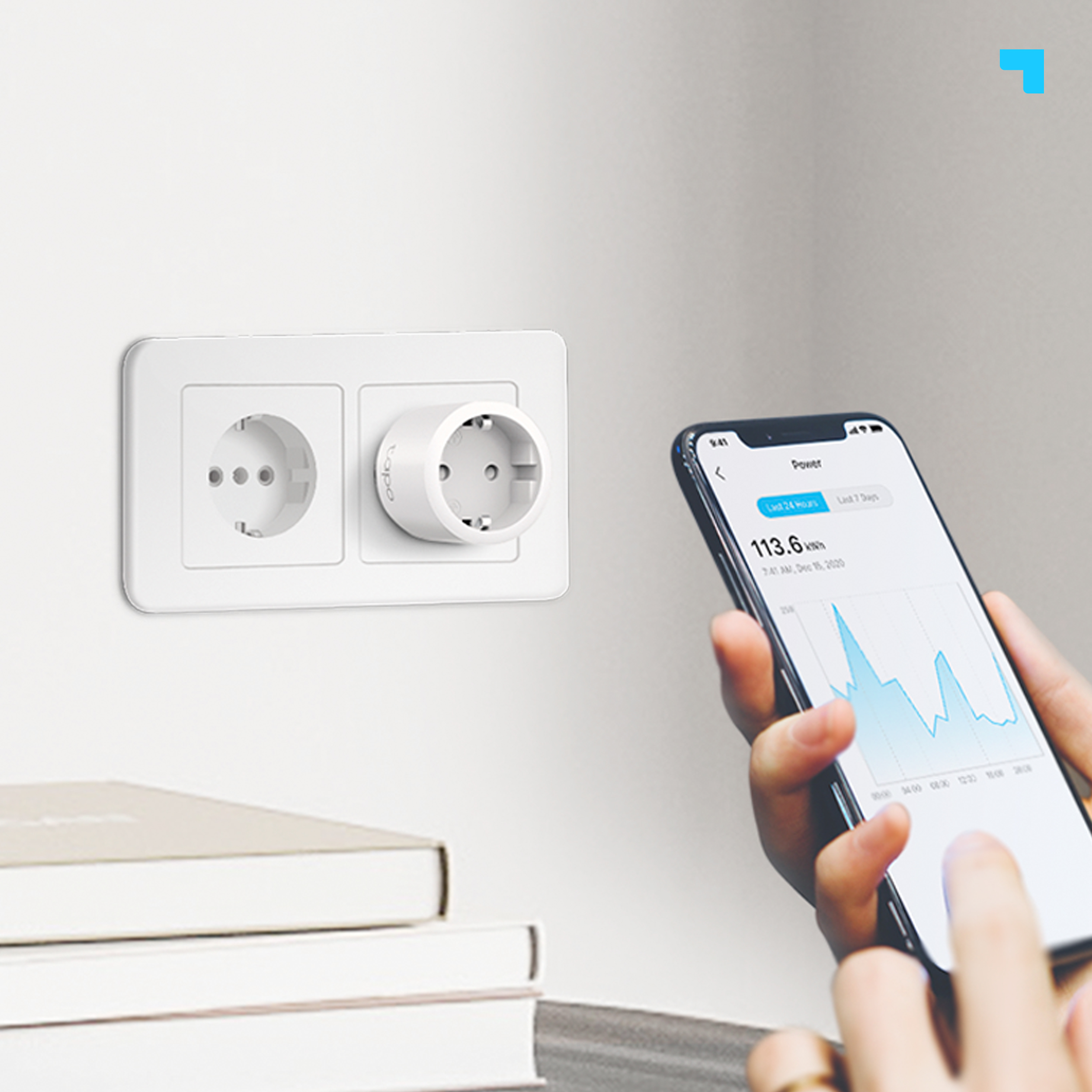 Enchufe inteligente en una pared con un teléfono que muestra estadísticas de consumo de energía.