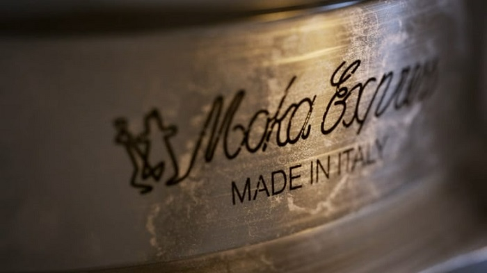 'Moka Express' és 'MADE IN ITALY' felirat egy fémfelületen, közelről.