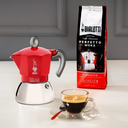 Piros Bialetti moka kávéfőző kávéval és babzsákkal.
