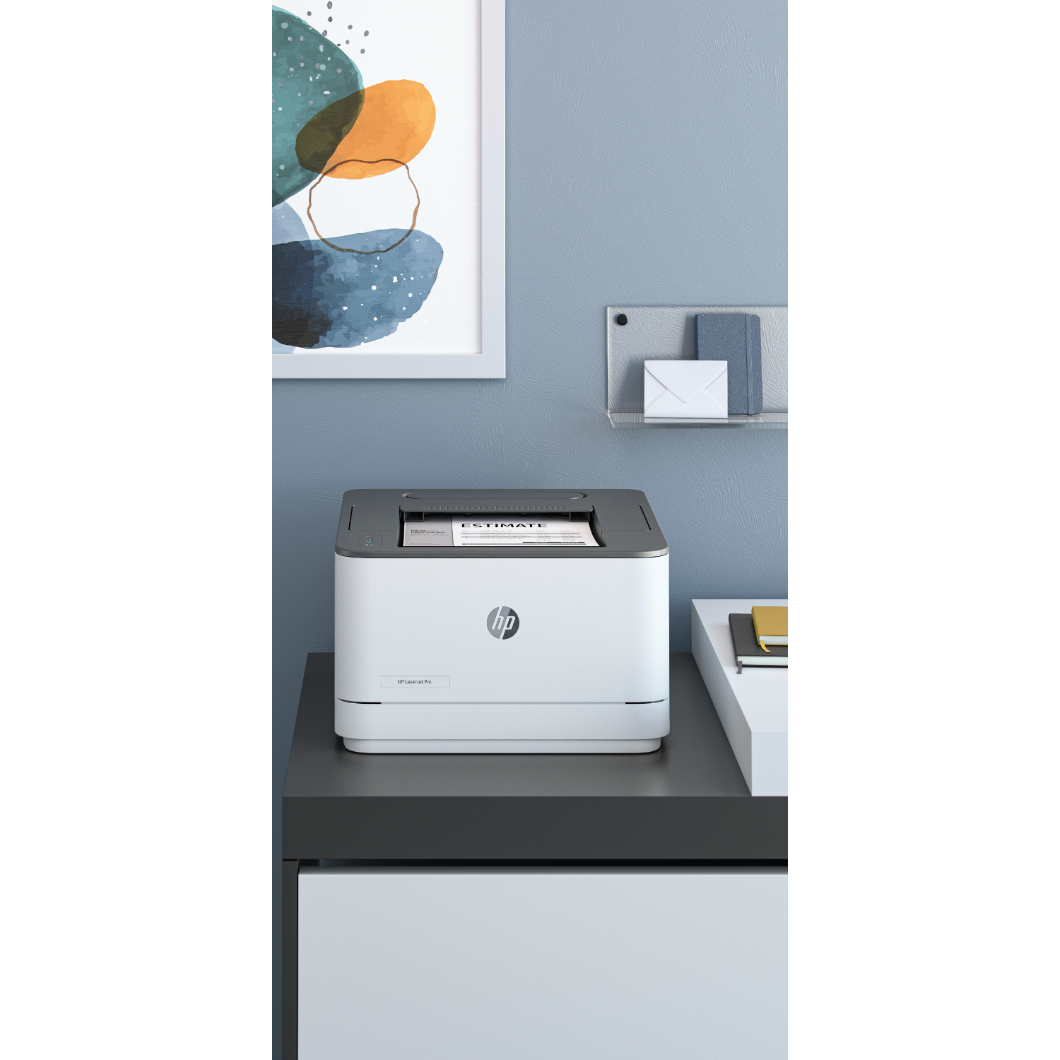 A white HP printer on a dark grey desk. A painting and a white shelf on the wall.