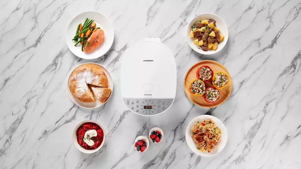 Białe urządzenie Philips z różnymi potrawami z gotowanego jedzenia wokół niego, z perspektywy z góry.