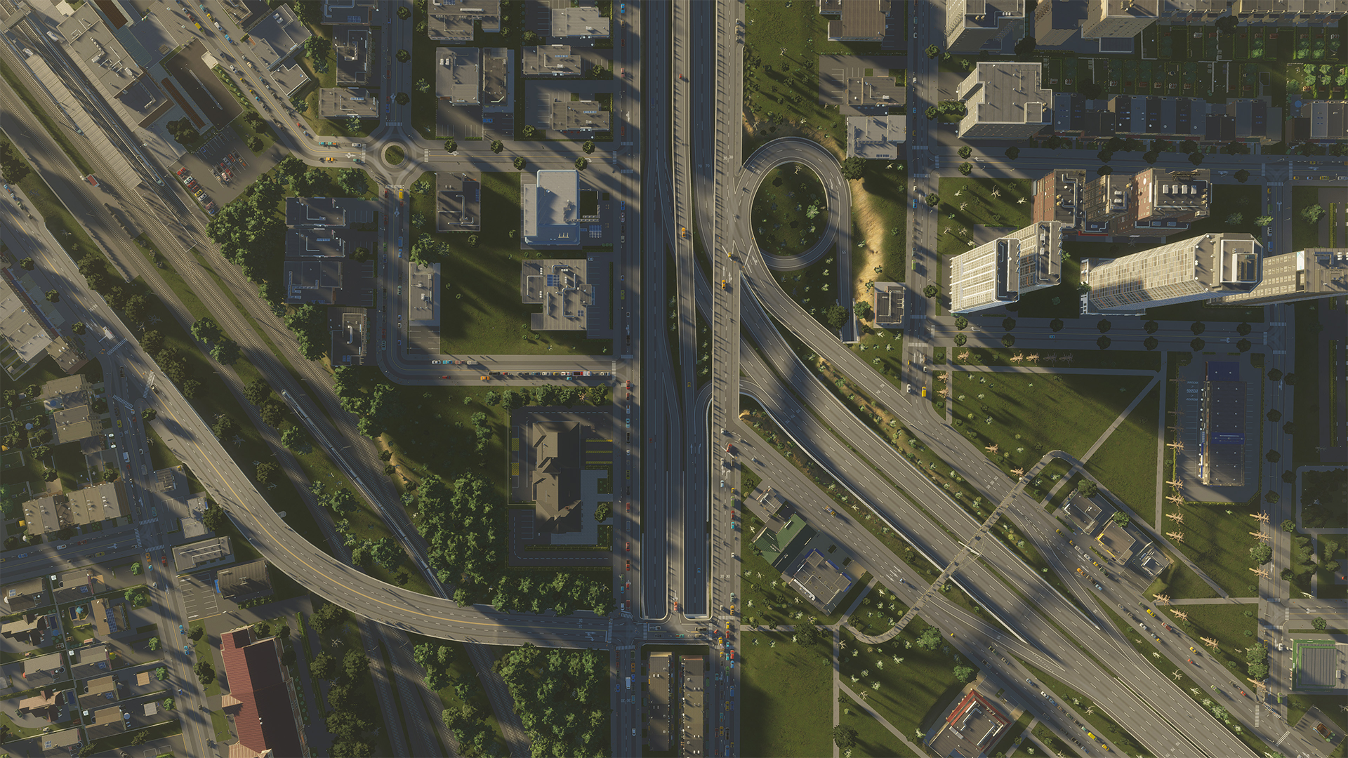 Luftaufnahme einer Stadt mit Autobahnen, Gebäuden und Grünflächen. Straßen und Gebäude dominieren.