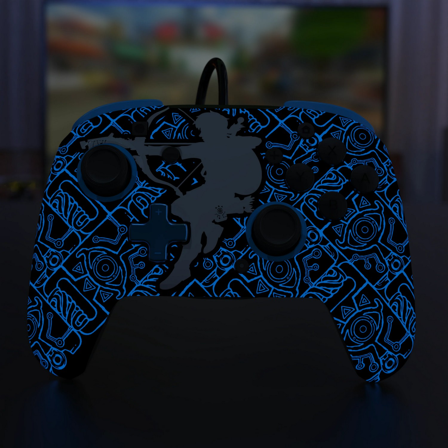 Manette de jeu avec un motif lumineux unique et une figurine sur la surface noire.
