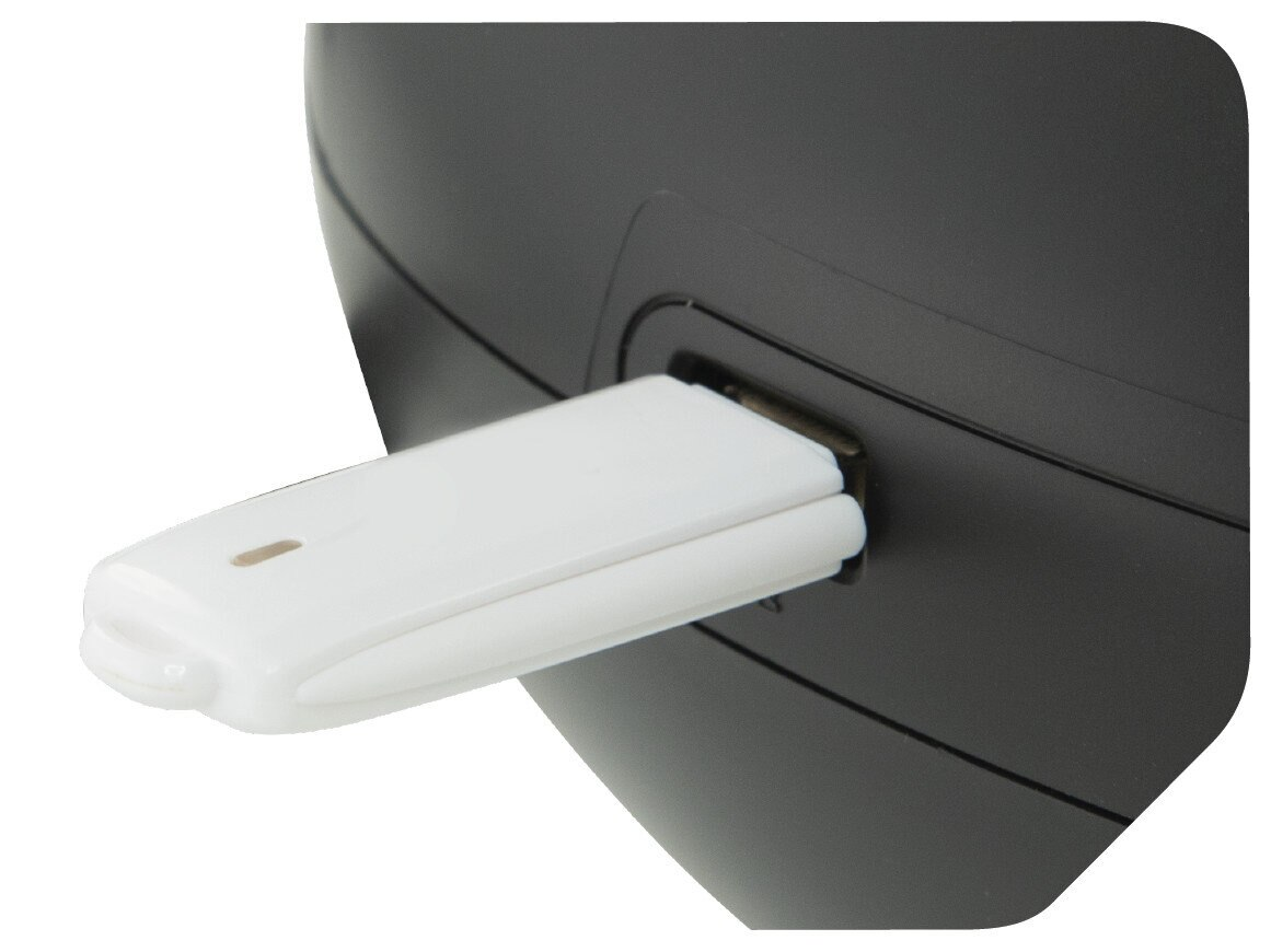 Biały pendrive jest podłączony do czarnego urządzenia.