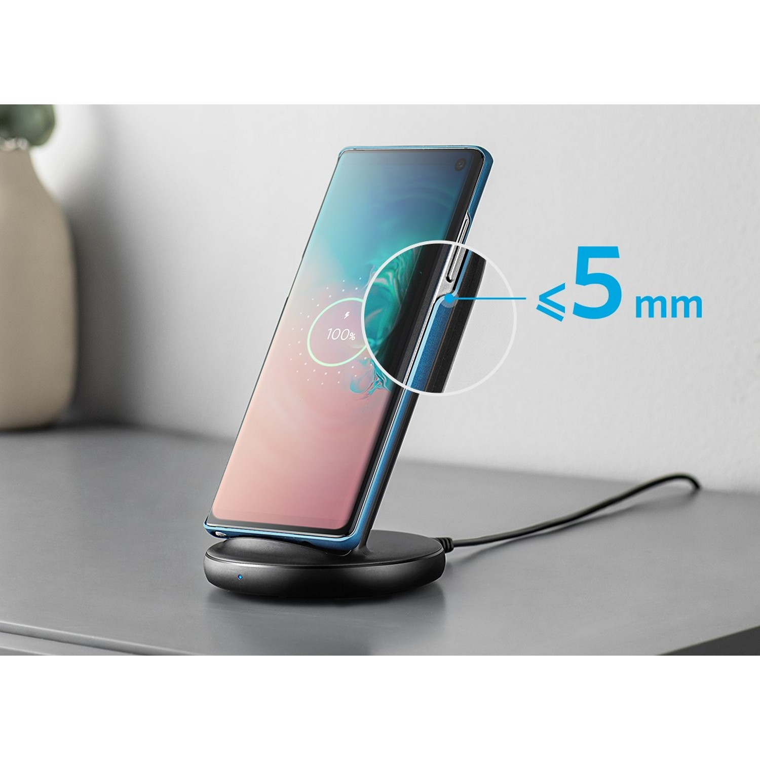 Een smartphone die draadloos oplaadt op een zwart oplaadpad, met een indicatie van 100% lading.