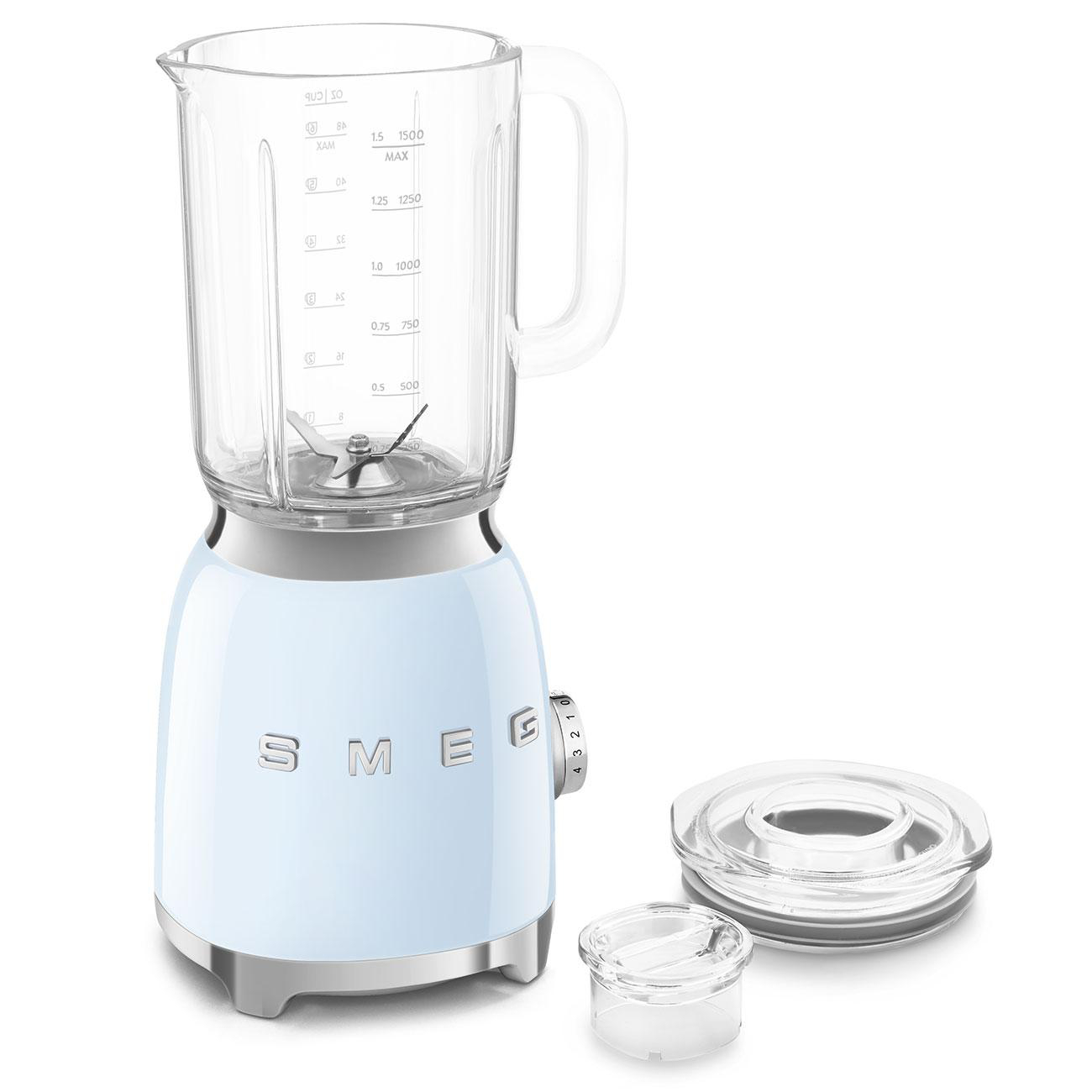 Ein hellblauer Mixer mit einem Glaskrug und Deckel. Es gibt auch kleine, klare Zubehörteile.