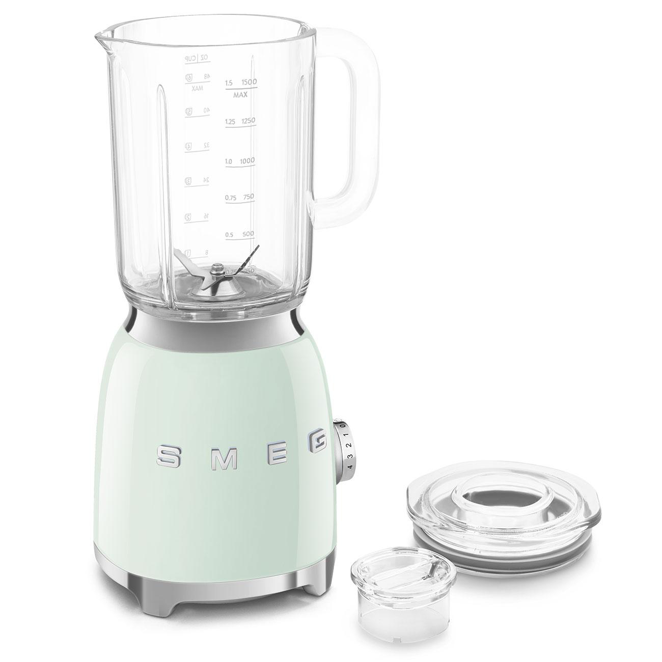 Ein mintgrüner SMEG-Mixer mit Glasbehälter und Deckel, plus einem kleinen, transparenten Behälter.