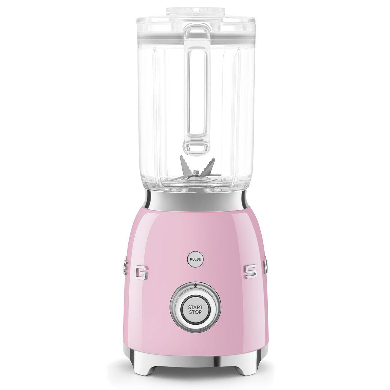 Rosa Smeg-Mixer mit einem transparenten Krug auf weißer Oberfläche. Der Mixer hat eine Start/Stopp-Taste.