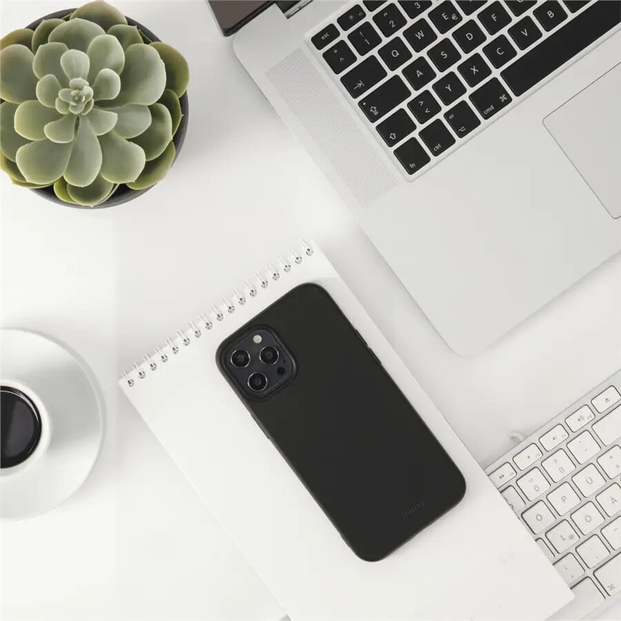 Laptop, telefon na notatniku, kawa i sukulent na białym biurku. Widok z góry.