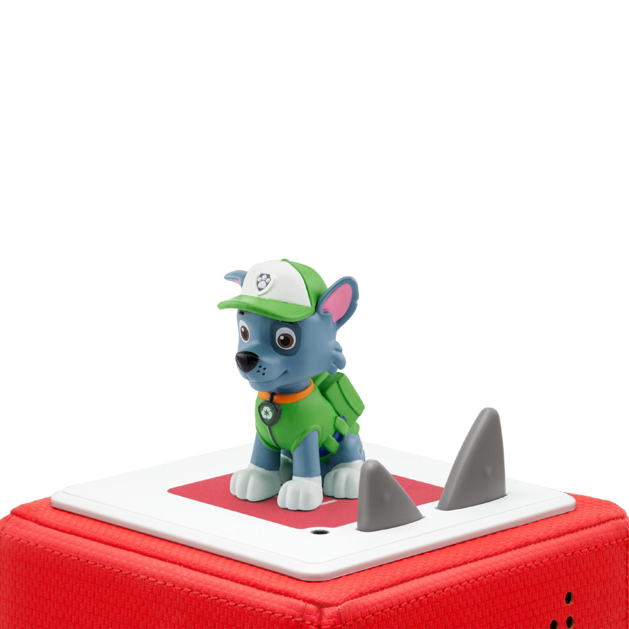 Eine Spielfigur eines Hundes mit Hut steht auf einer rot-weißen Plattform mit Haifischflossen.
