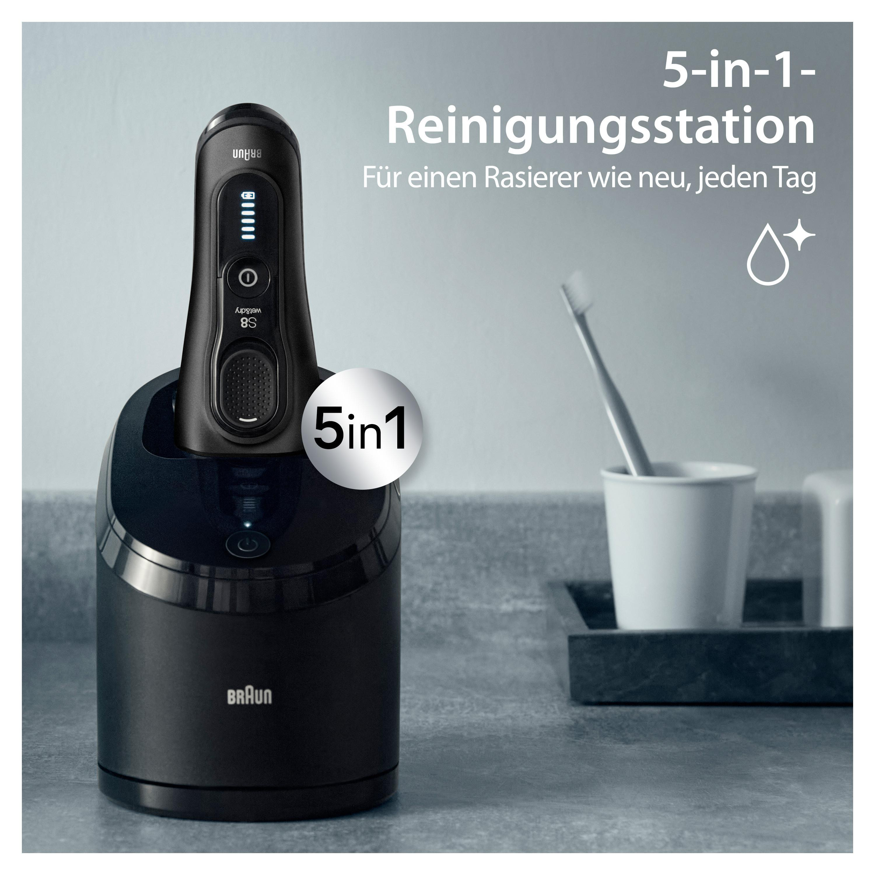 Schwarzer Rasierer in einer Ladestation, mit deutschem Text. Eine Zahnbürste im Halter.