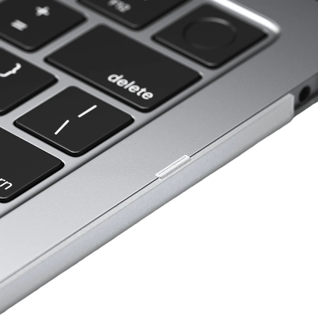 Primo piano dell'angolo di una tastiera di un laptop con il tasto 'canc' e un bordo argentato.