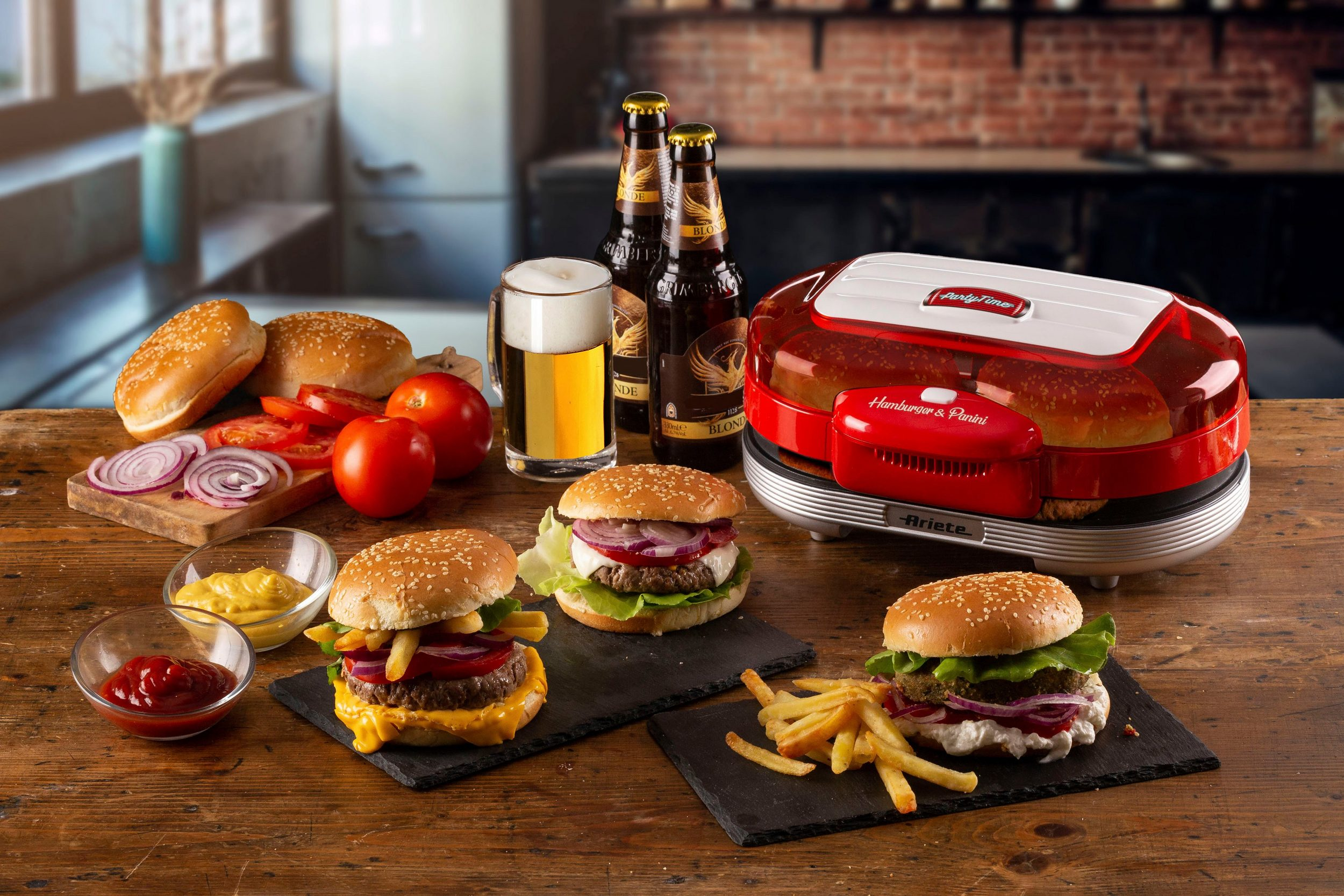 Hamburger, patatine fritte, birra e un'hamburgeriera disposti su un tavolo di legno.