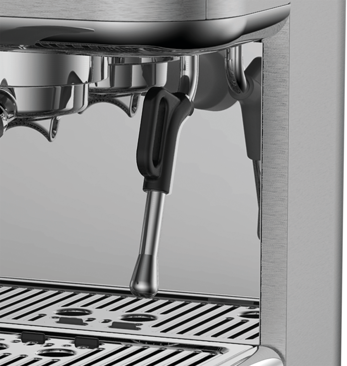 Primo piano di una macchina per espresso argentata con portafiltro e manico nero.