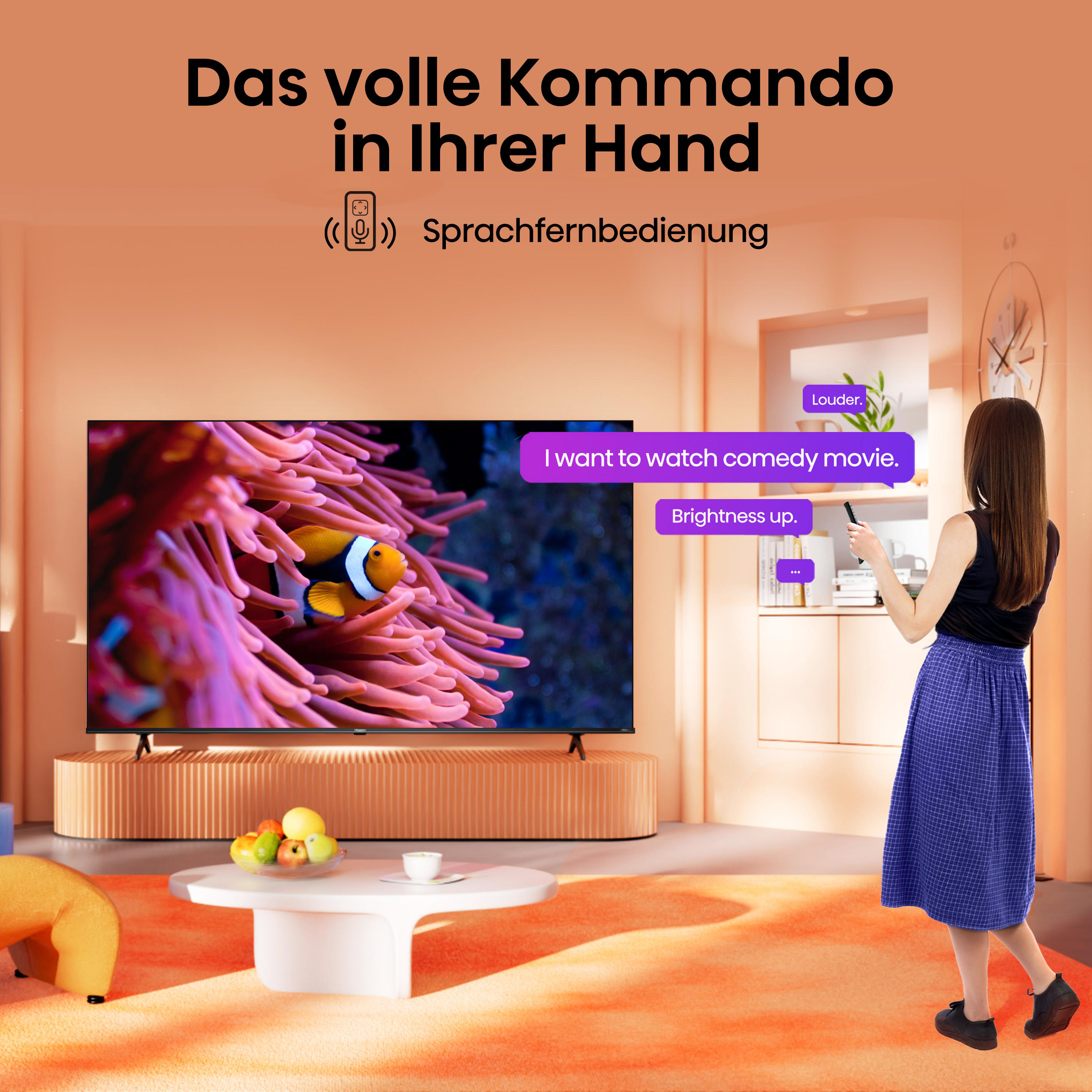 Frau bedient TV mit Fernbedienung, zeigt Fisch in Anemone, mit Sprechblasen.